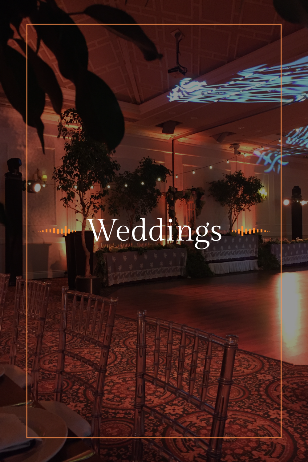 Elegantly decorated wedding reception venue with plants, ambient lighting, and a dance floor.