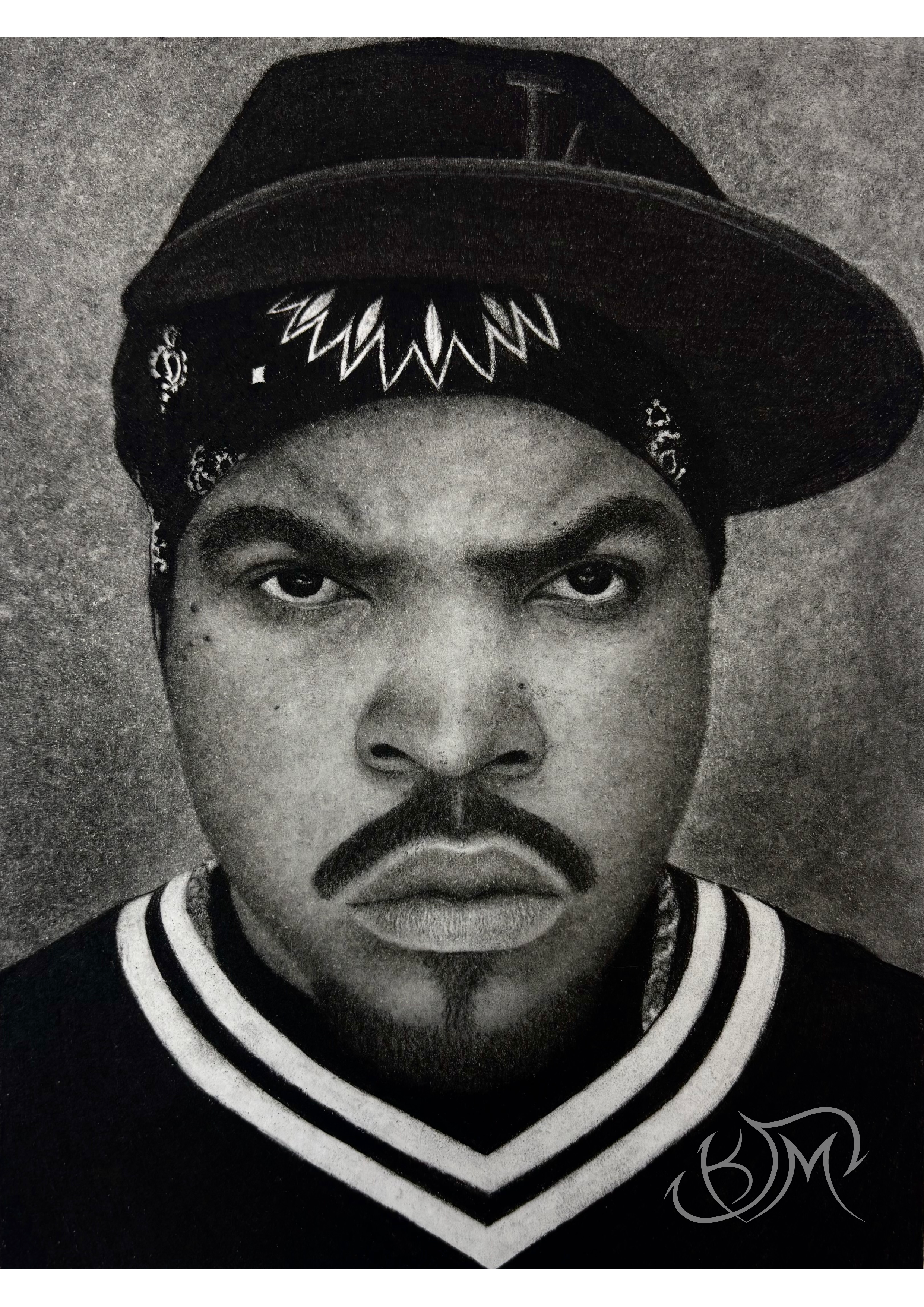 Black and white portrait of Ice Cube wearing a striped varsity jacket and a LA baseball cap with a pattern, looking directly at the camera.