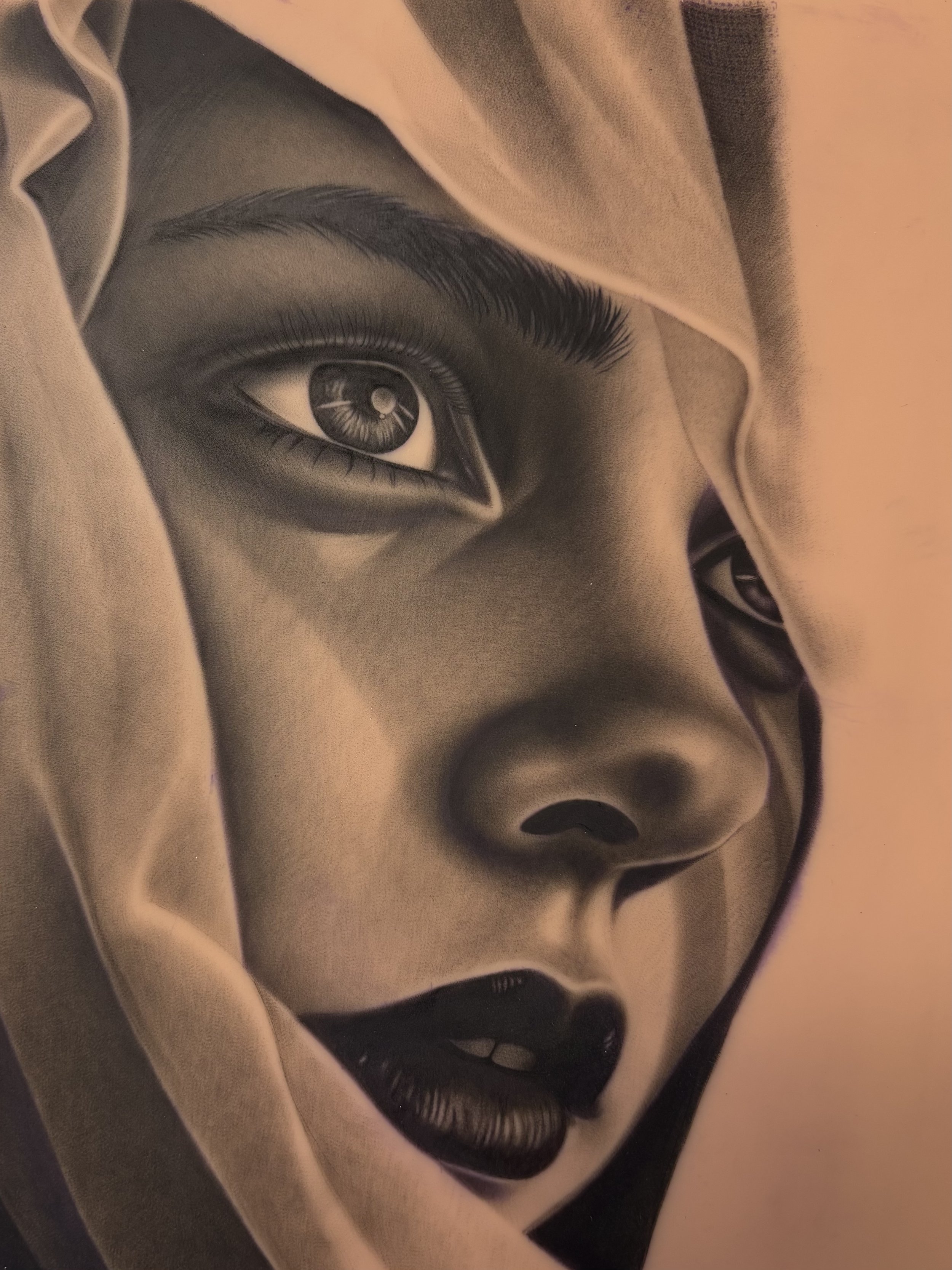 A close-up black and white drawing of a woman's face, focusing on her eye, eyebrow, and part of her nose and lips, with cloth partially covering her head.
