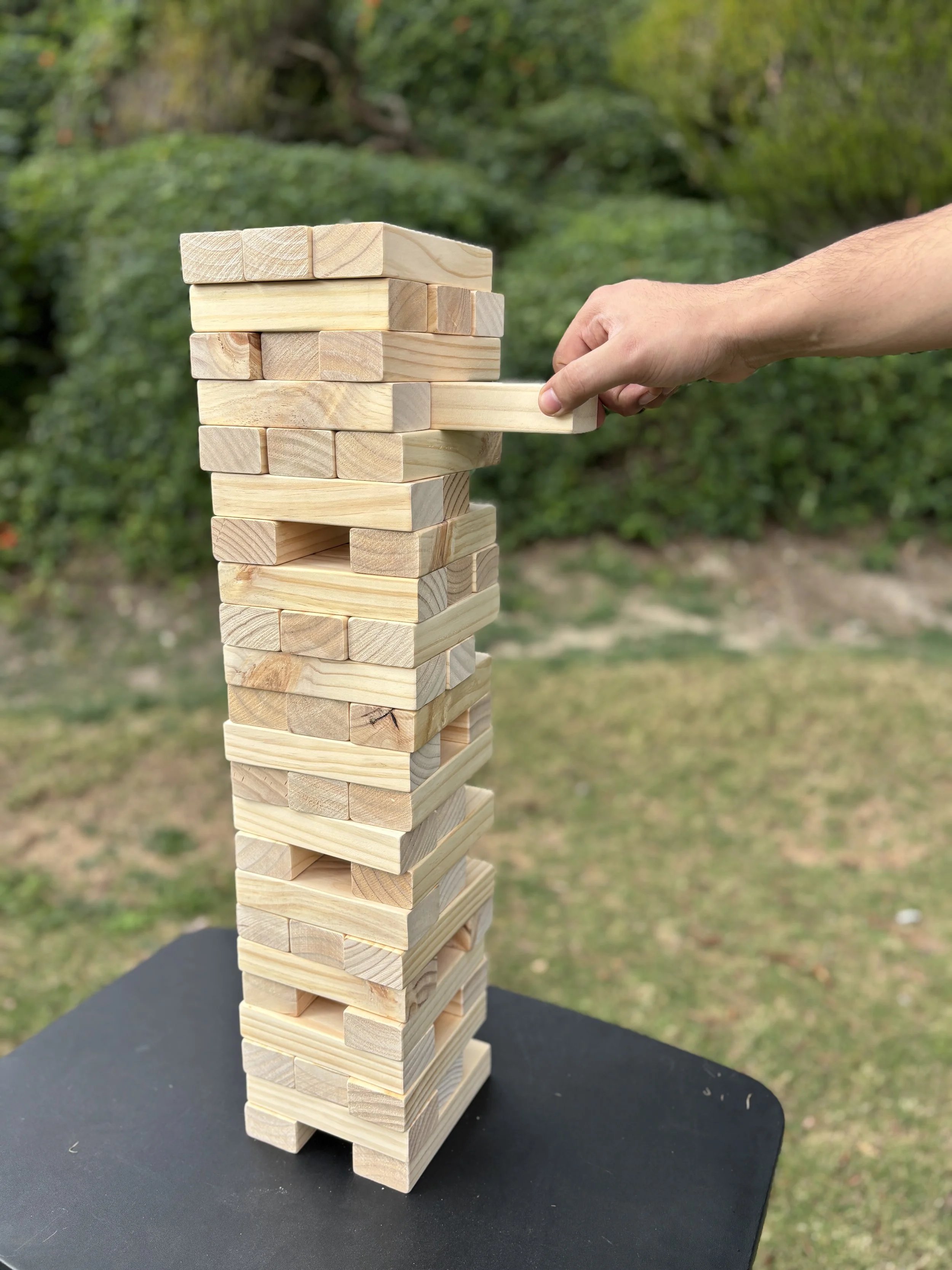Giant Jenga game rental at an outdoor family gathering in South Orange County.