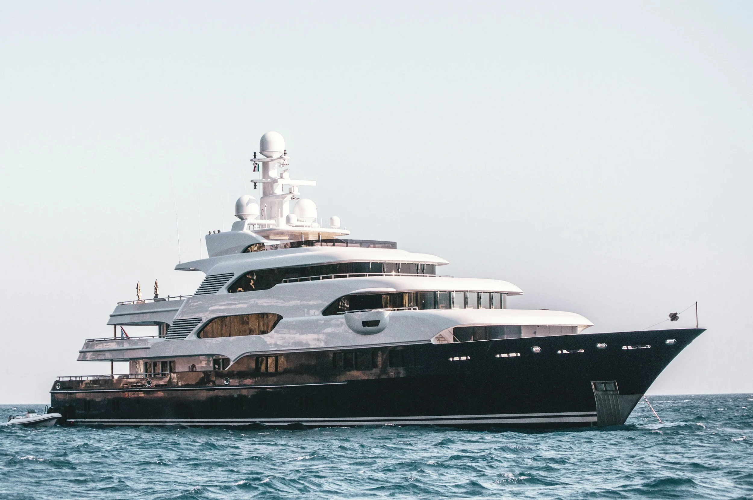 A large luxury yacht with multiple decks sailing on the ocean.