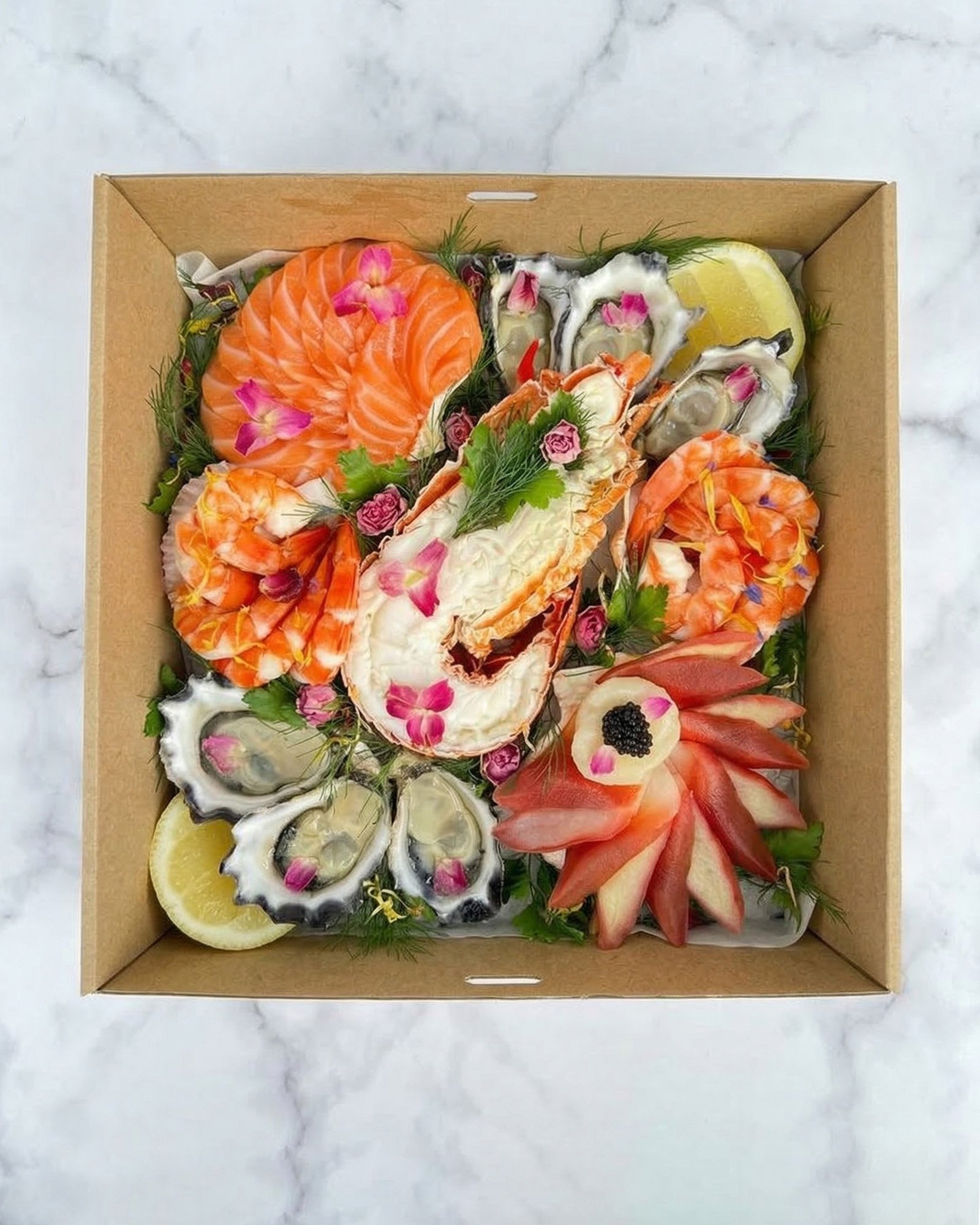Assorted seafood platter featuring smoked salmon, oysters, shrimp, lemon slices, and garnishes, arranged in a cardboard box.