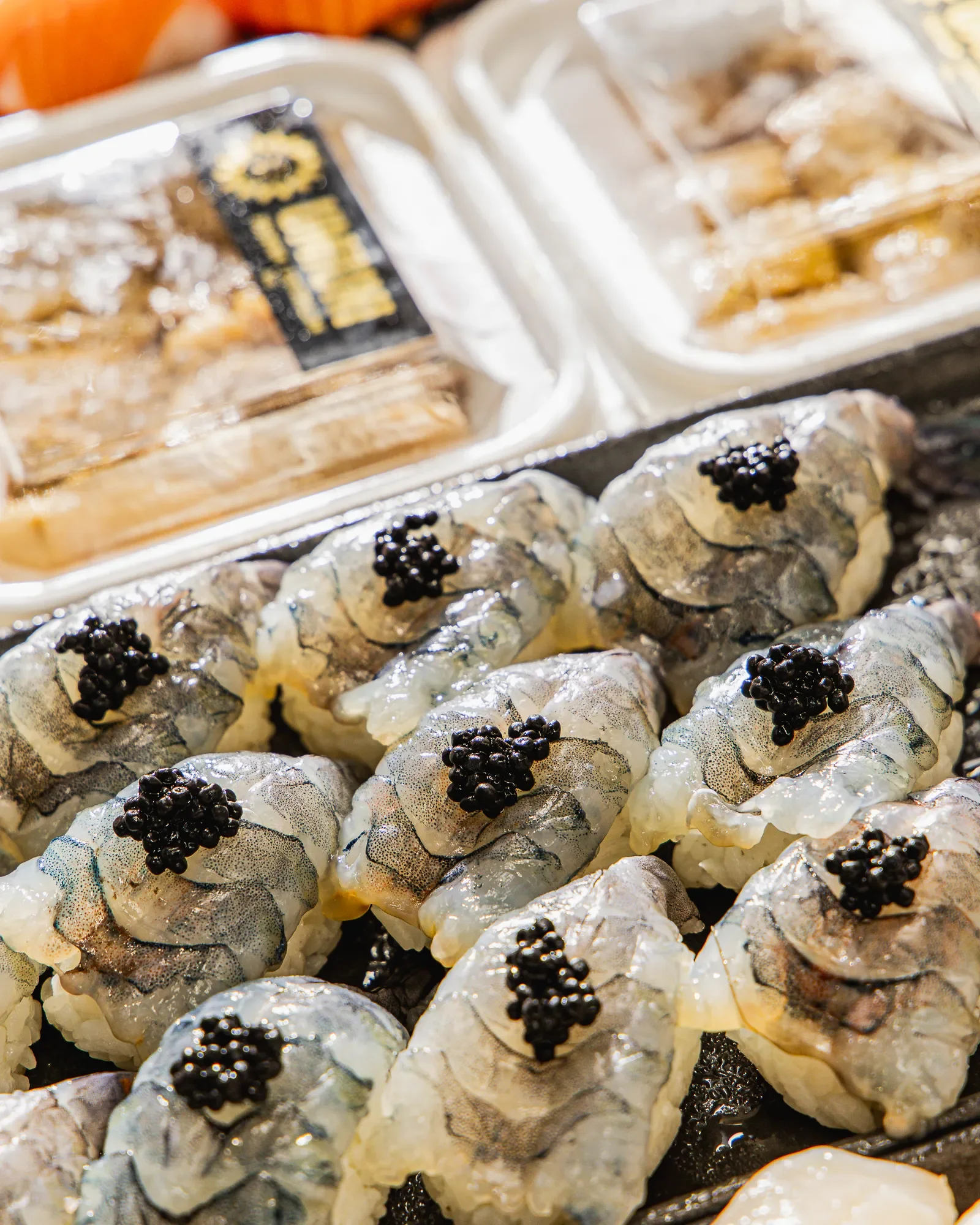 Close-up of sushi rolls topped with black caviar.
