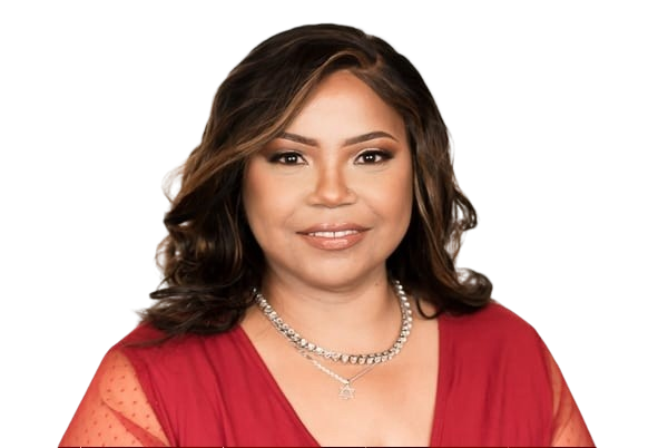 A woman with medium-length, wavy brown hair wearing a red dress with sheer sleeves and a pearl necklace, smiling at the camera against a black background.