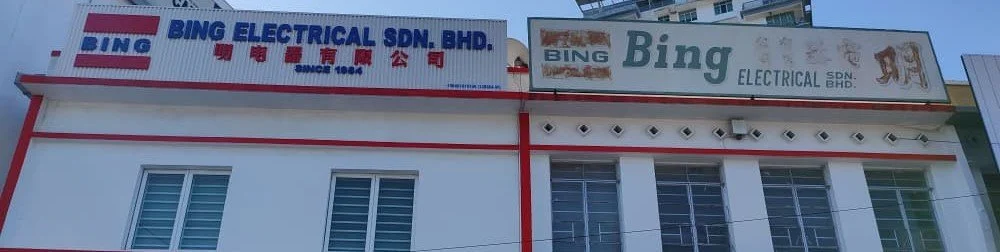 Exterior of a building with two signs for Bing Electrical Sdn. Bhd., one in English and one in Malay, featuring company names and logos.