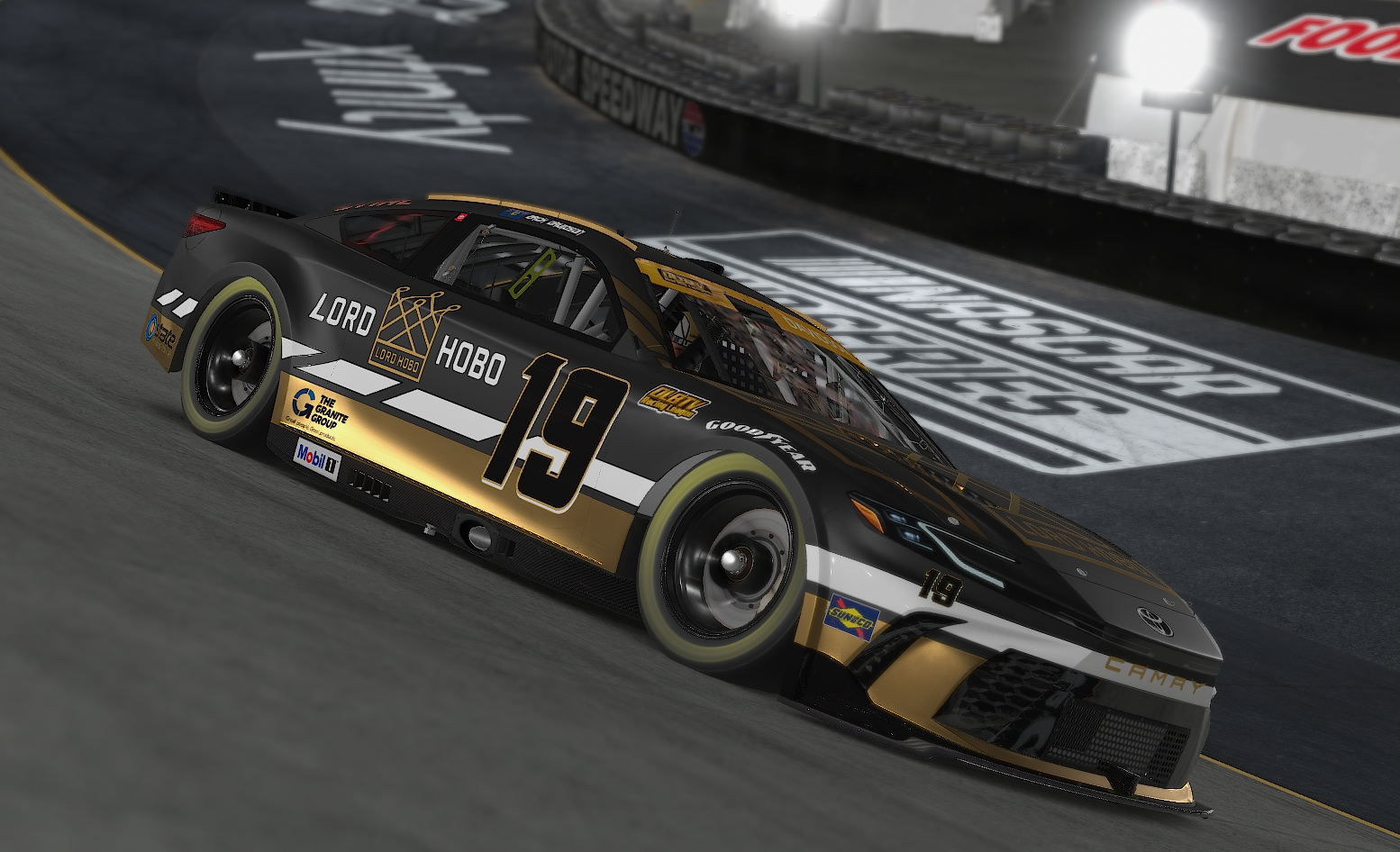 A black and gold Toyota race car with the number 19, sponsored by Lord Hobo, on a race track at night.