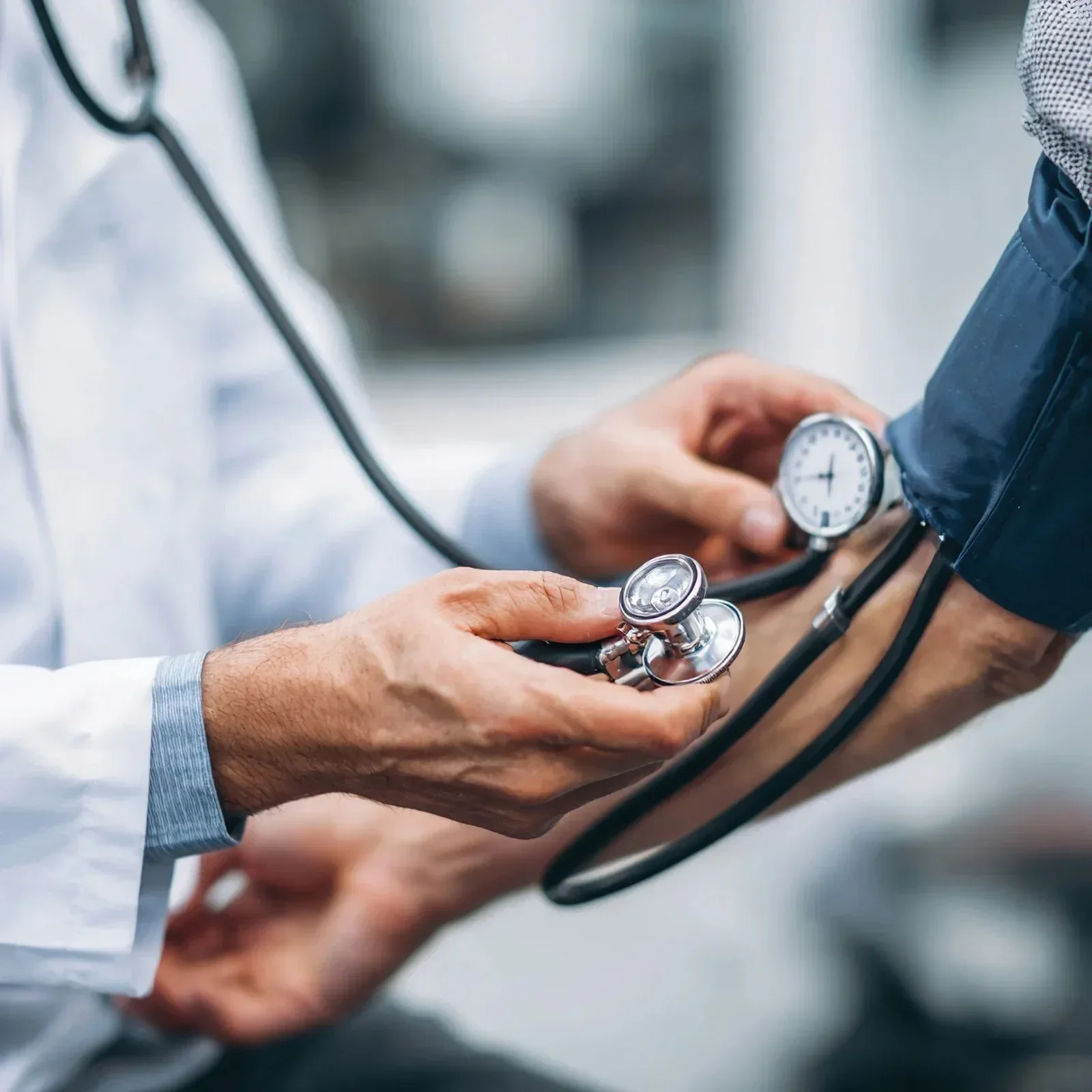 A doctor using a sphygmomanometer to measure a patient's blood pressure