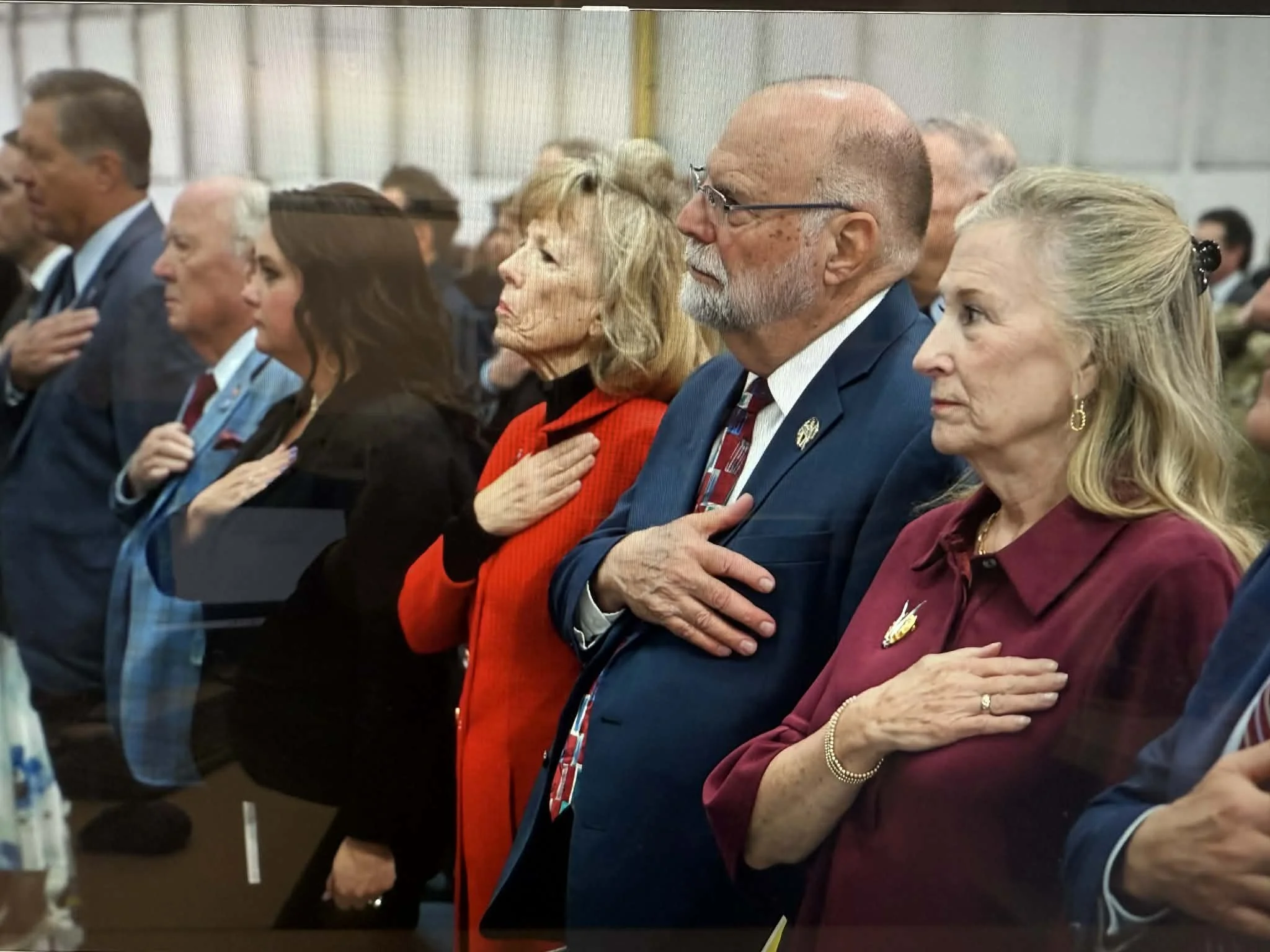 Mark Jantzer stands with other leaders during the United States National Anthem with hands over their hearts