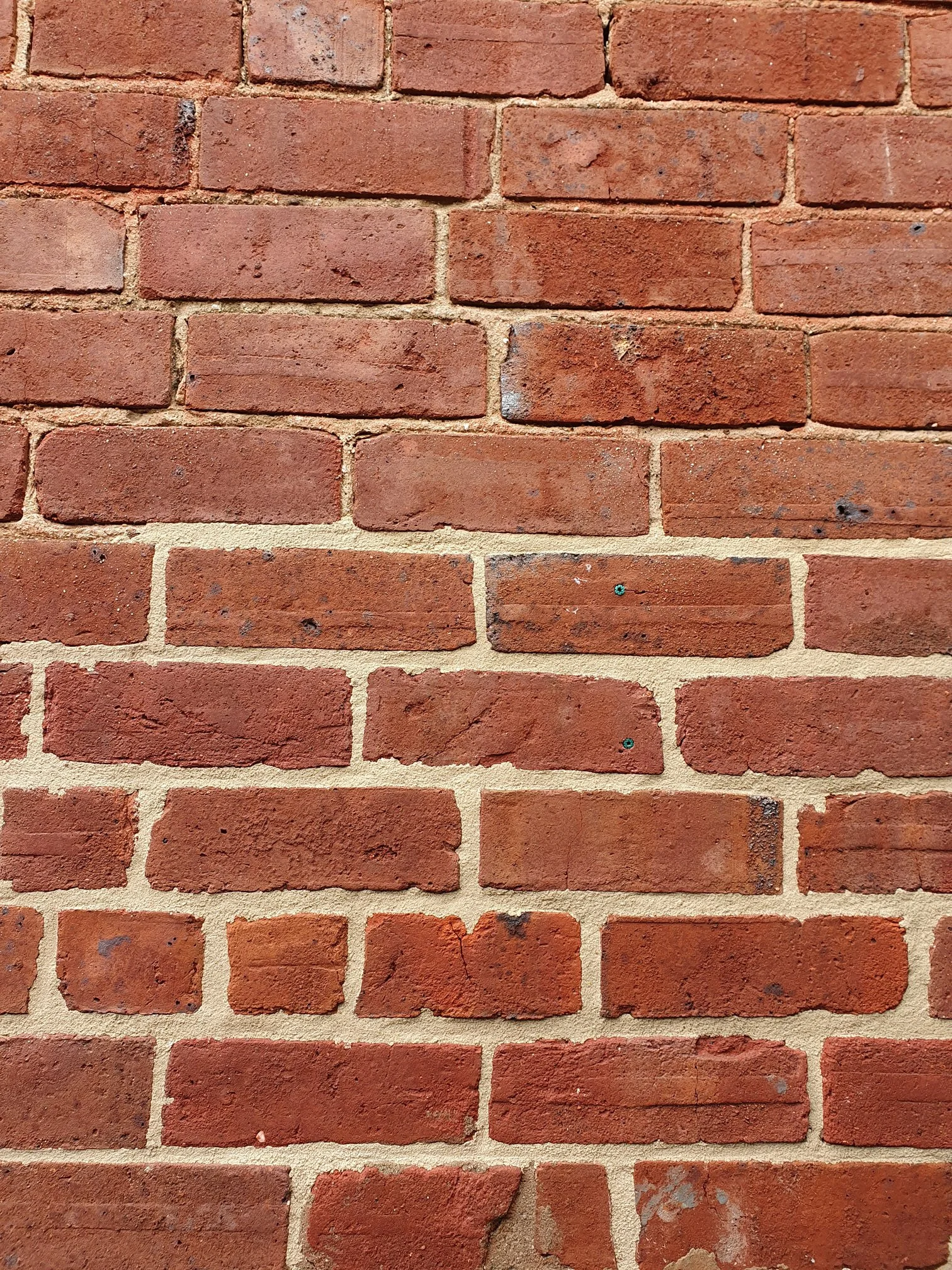 Close-up of a red brick wall with mortar in between the bricks.