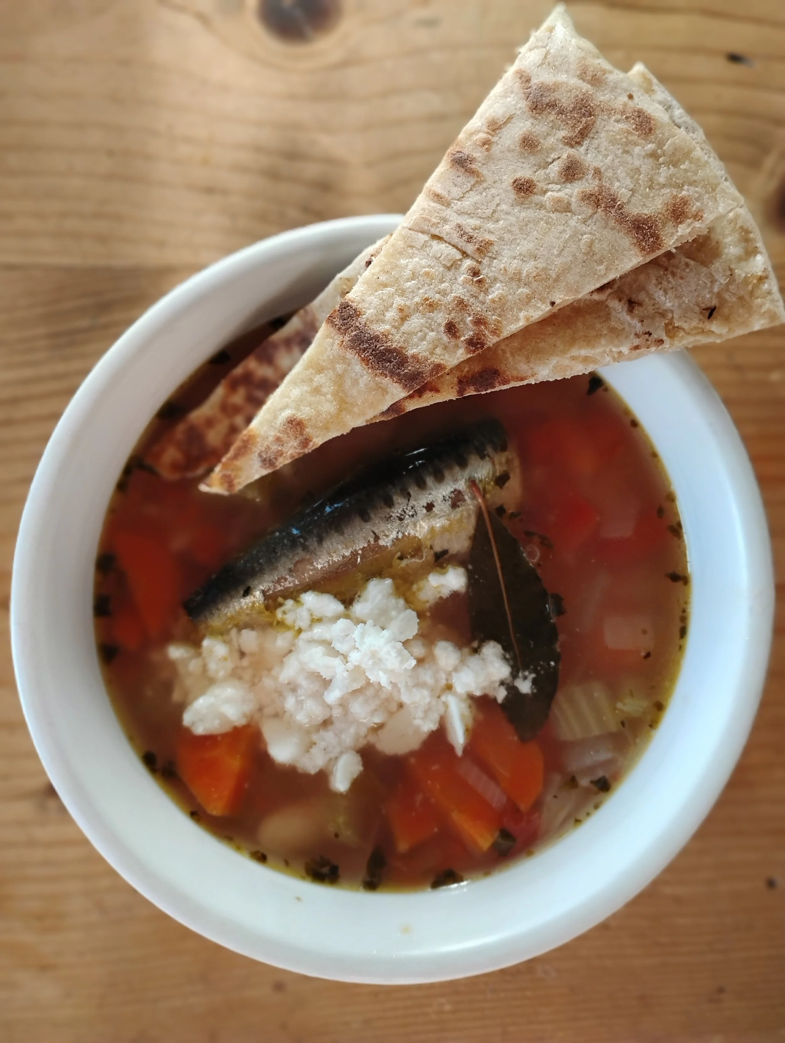Cozy Greek soup with sardines, feta and wedges of sourdough naan