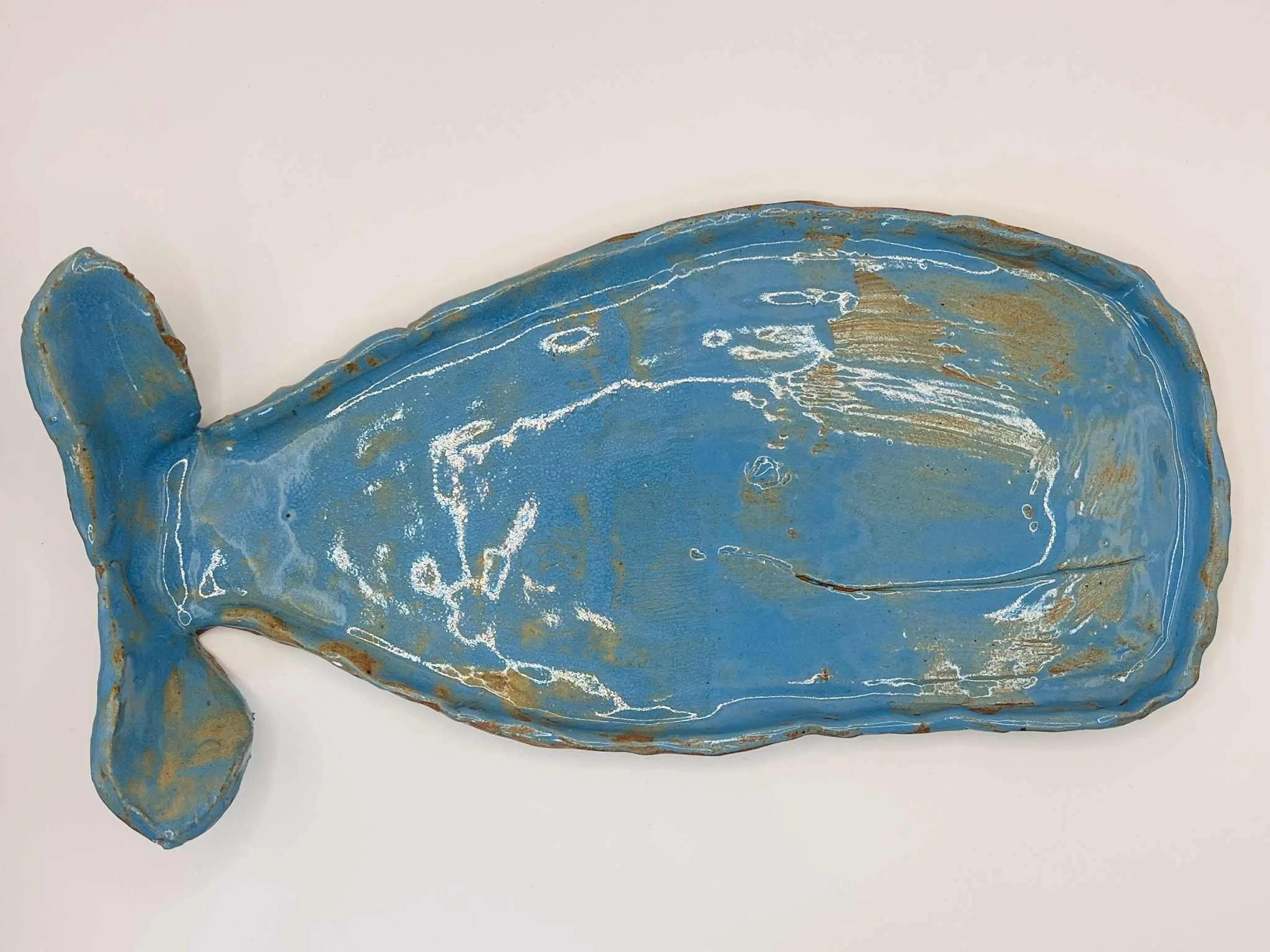 Blue whale-shaped ceramic play with a distressed, rustic finish set against a plain white background.