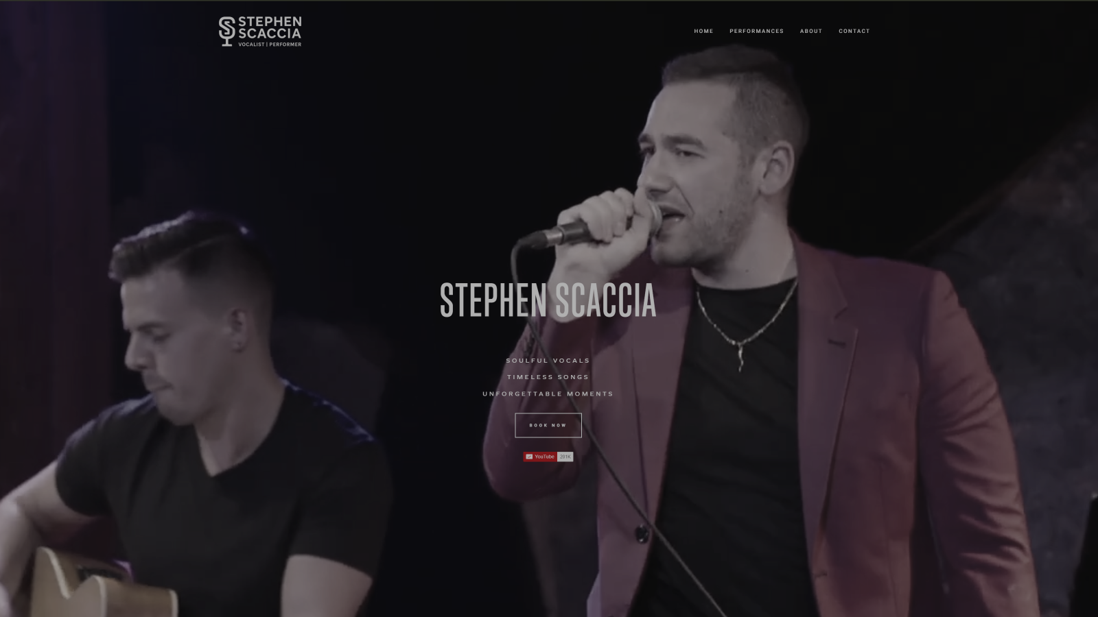 Screenshot of a musician named Stephen Scaccia performing, with his name and website overlayed, showing him singing into a microphone and another person playing guitar in the background.