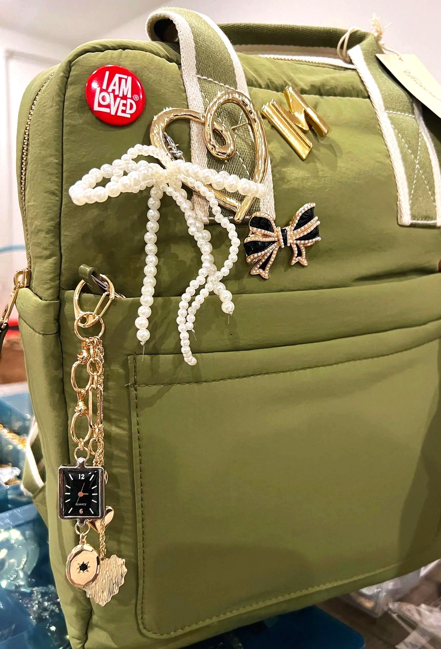 Backpack with brooches and charms on it from The Brooch Bar