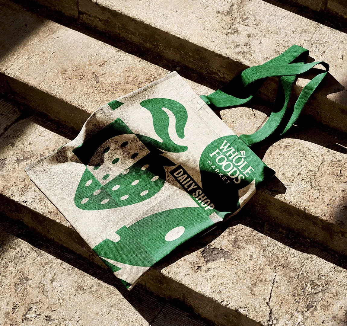 Stofftasche mit grüner Obst Grafik im Sonnenlicht auf einem Steinboden