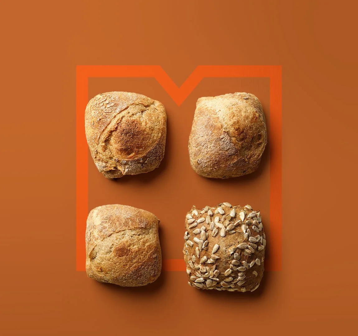 Migros Storytelling - Creating Stages - Vier Brötchen auf einem braunen Untergrund mit einer orangenen Umrandung