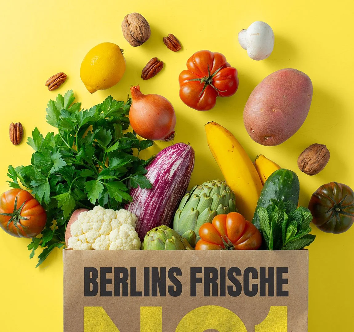 EDEKA No1 - Einkaufstasche Frische Gemüse und Nüsse in einer Papiertüte auf gelbem Hintergrund.