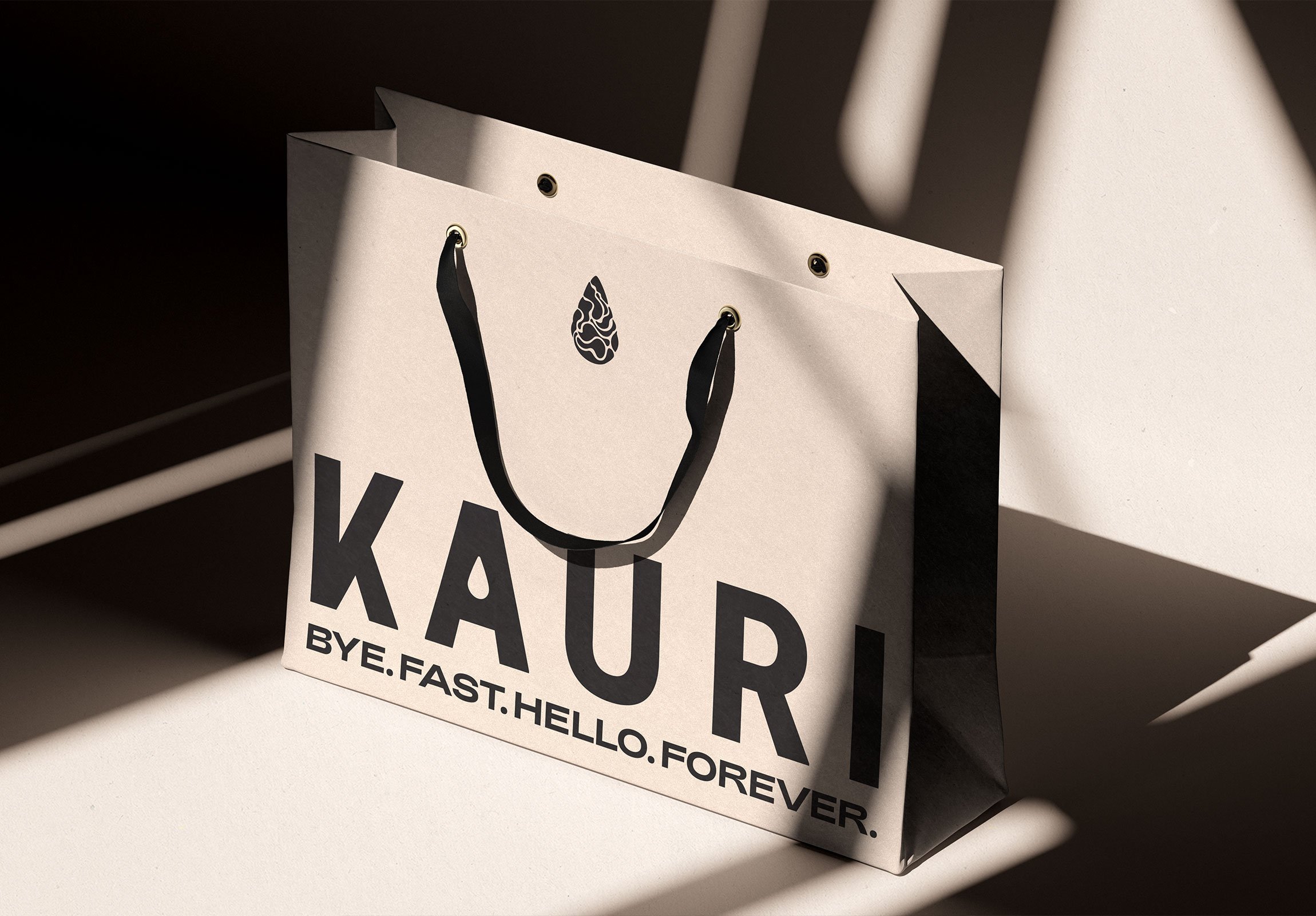 Kauri Stores, Schwarze und weiße Einkaufstasche mit der Aufschrift 'KAURI' und der Tagline 'BYE.FAST.HELLO.FOREVER.'