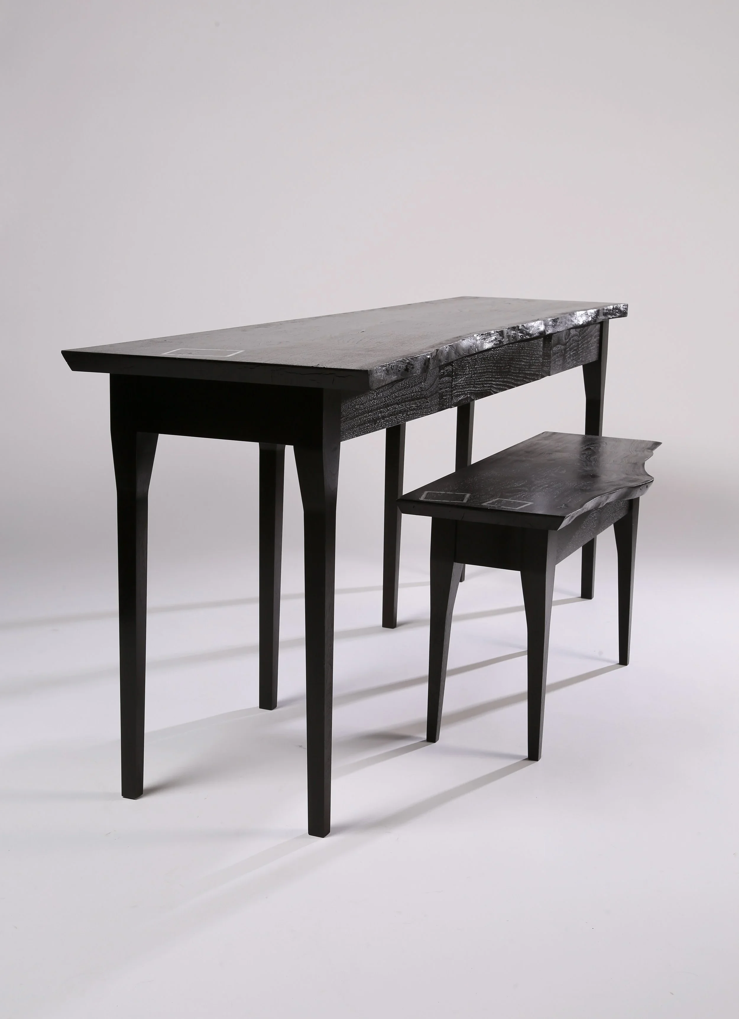 A custom furniture desk with live edge and marble inlay