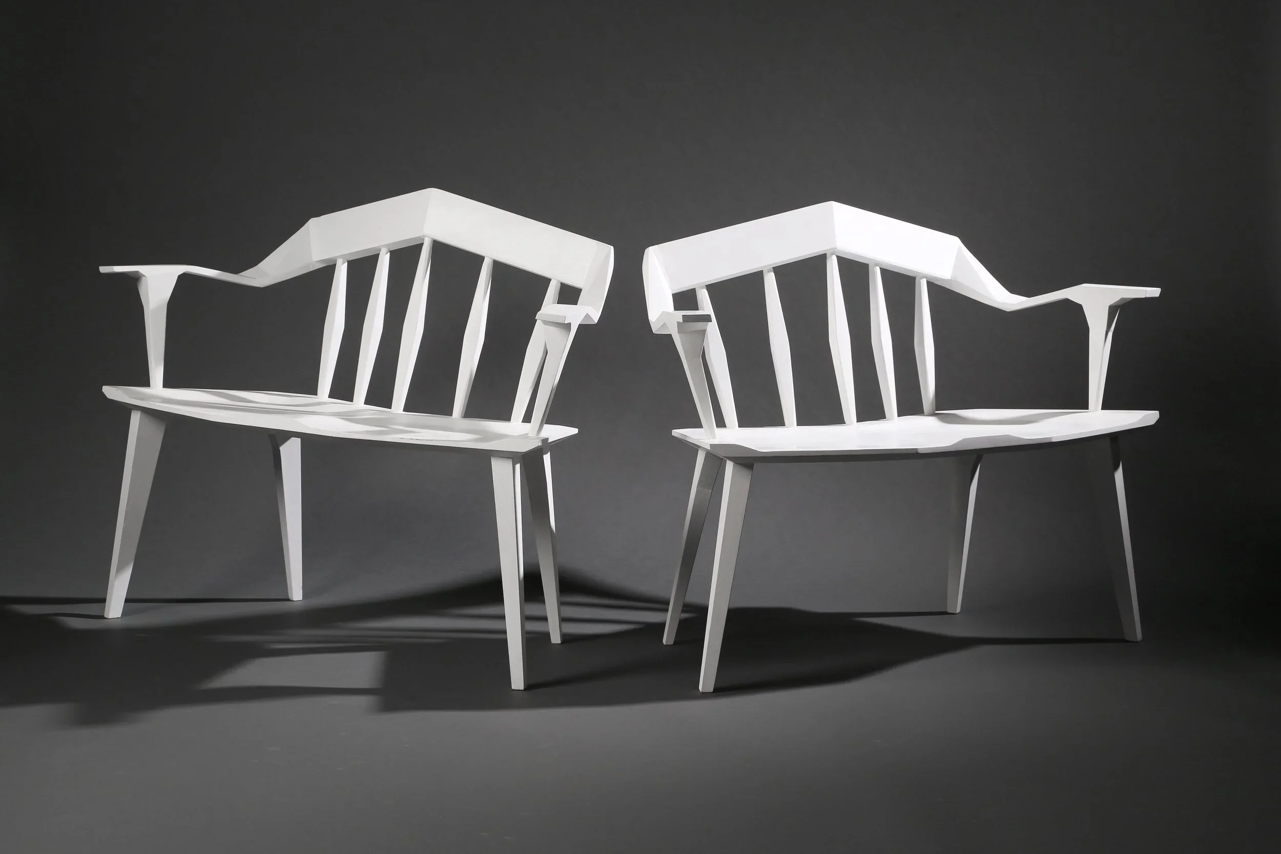 A pair of white angular custom furniture benches