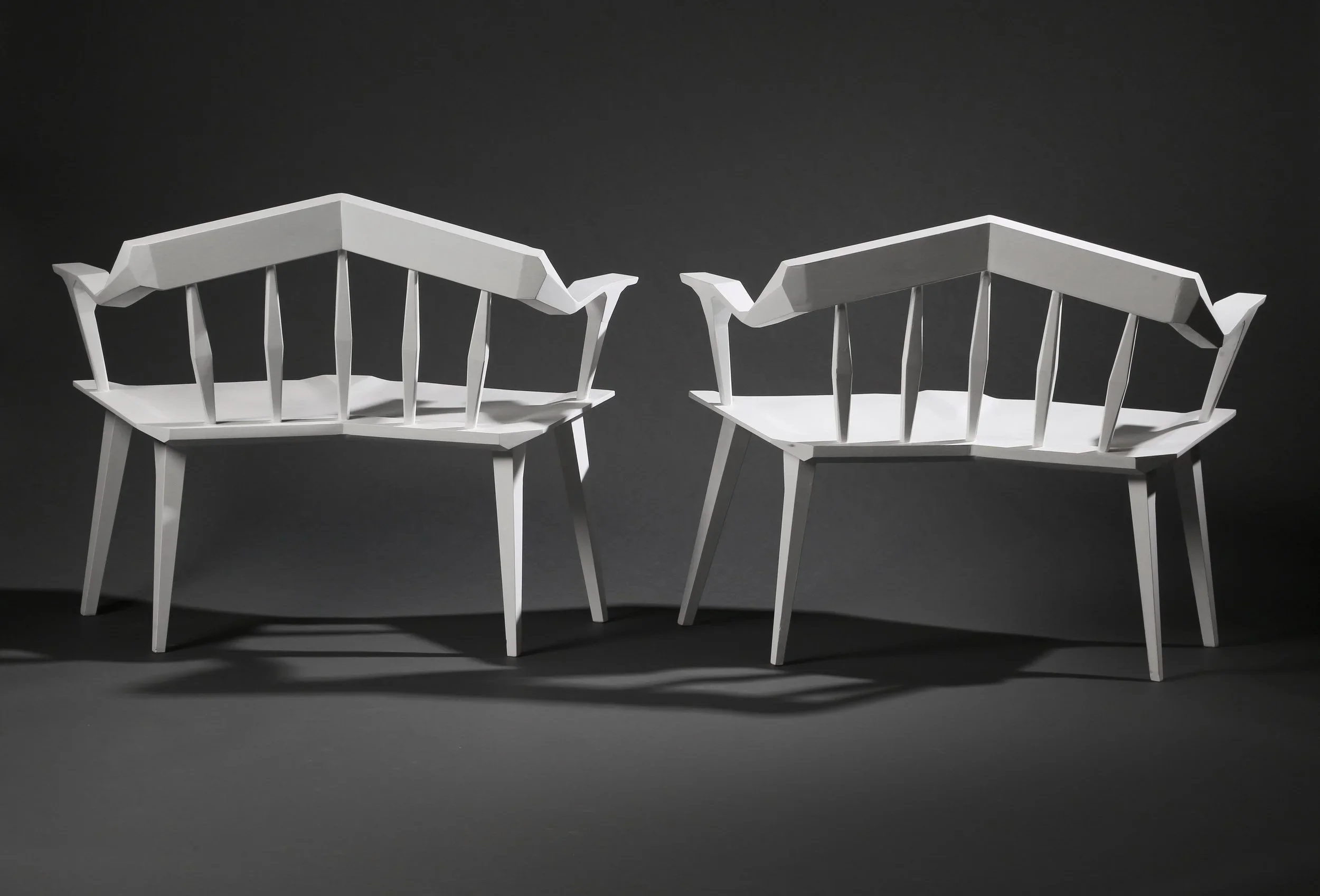 A pair of white angular custom furniture benches