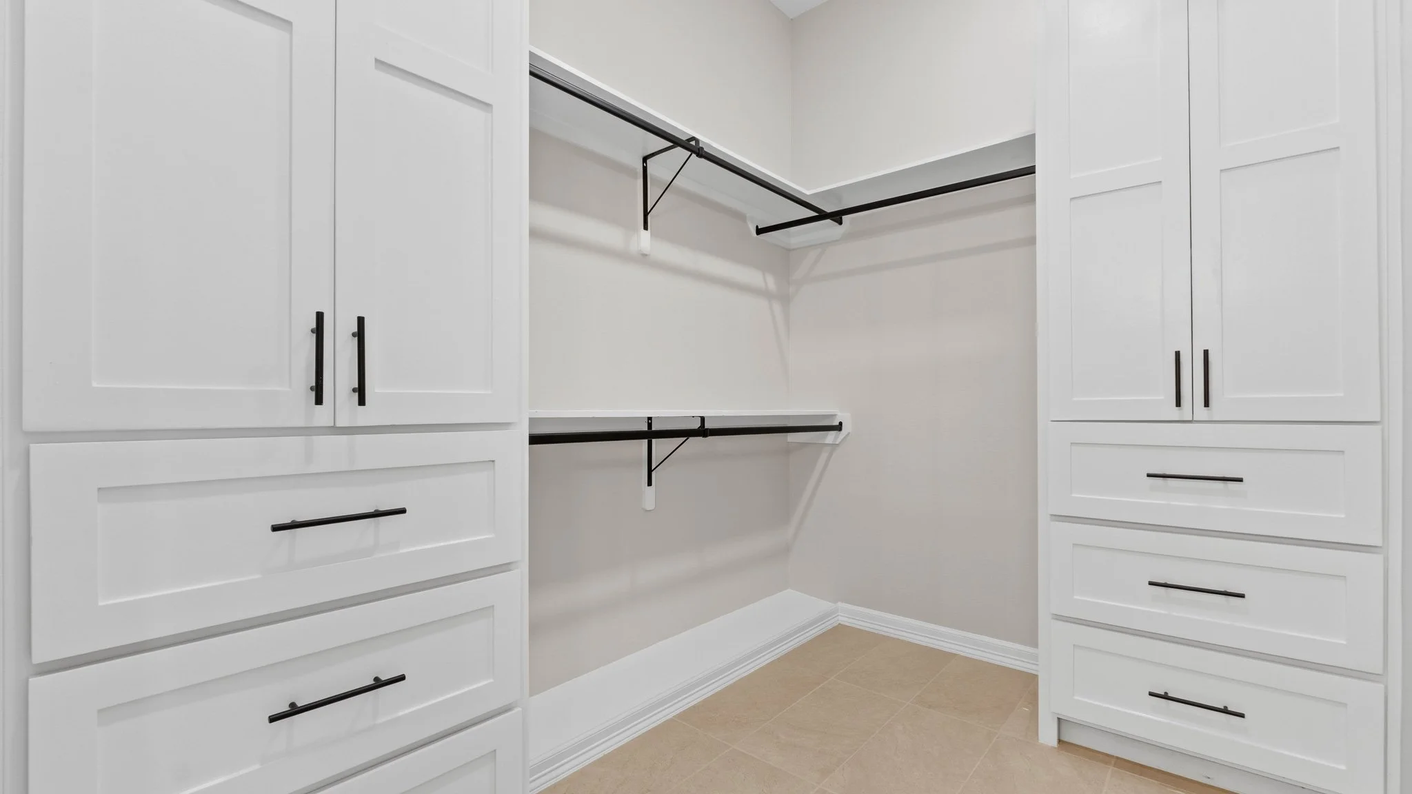 Vestidor vacío con gabinetes blancos y estantes negros