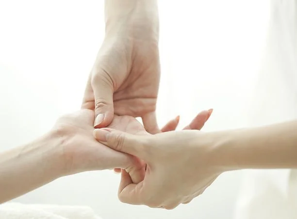 A person receiving a hand massage or physical therapy from another individual.