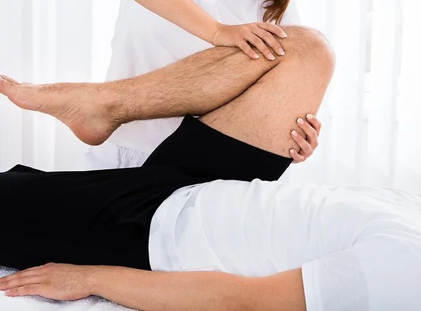 Physical therapy session with a therapist stretching a patient's leg.