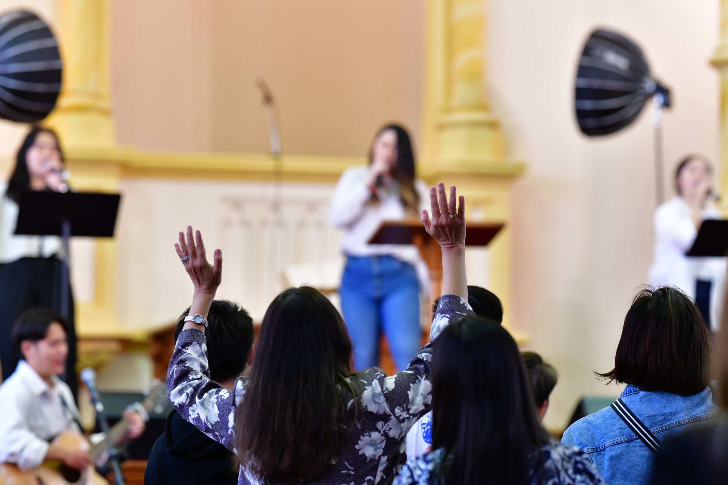 A woman with arms raised in worship.