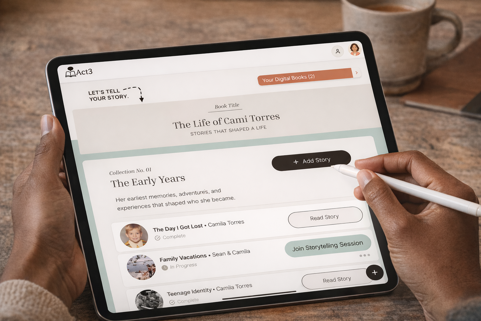 A person using a tablet to manage digital storybooks, with a section titled 'The Life of Cami Torres' and options to add and read stories, on a wooden table.
