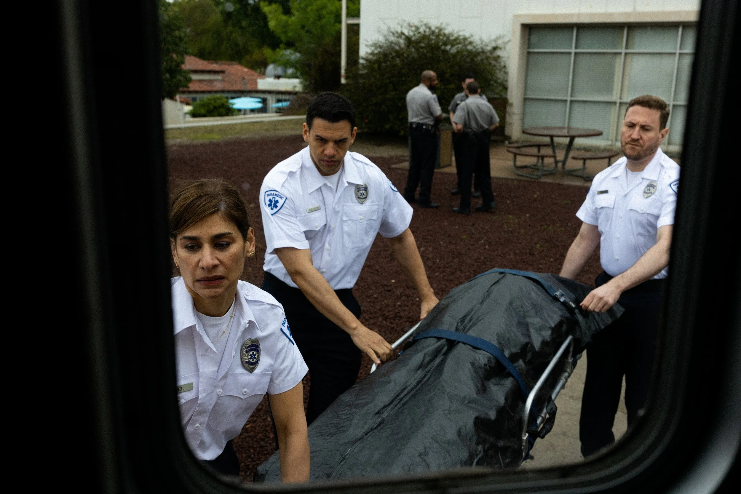 paramedics leading a gurney to an ambulance