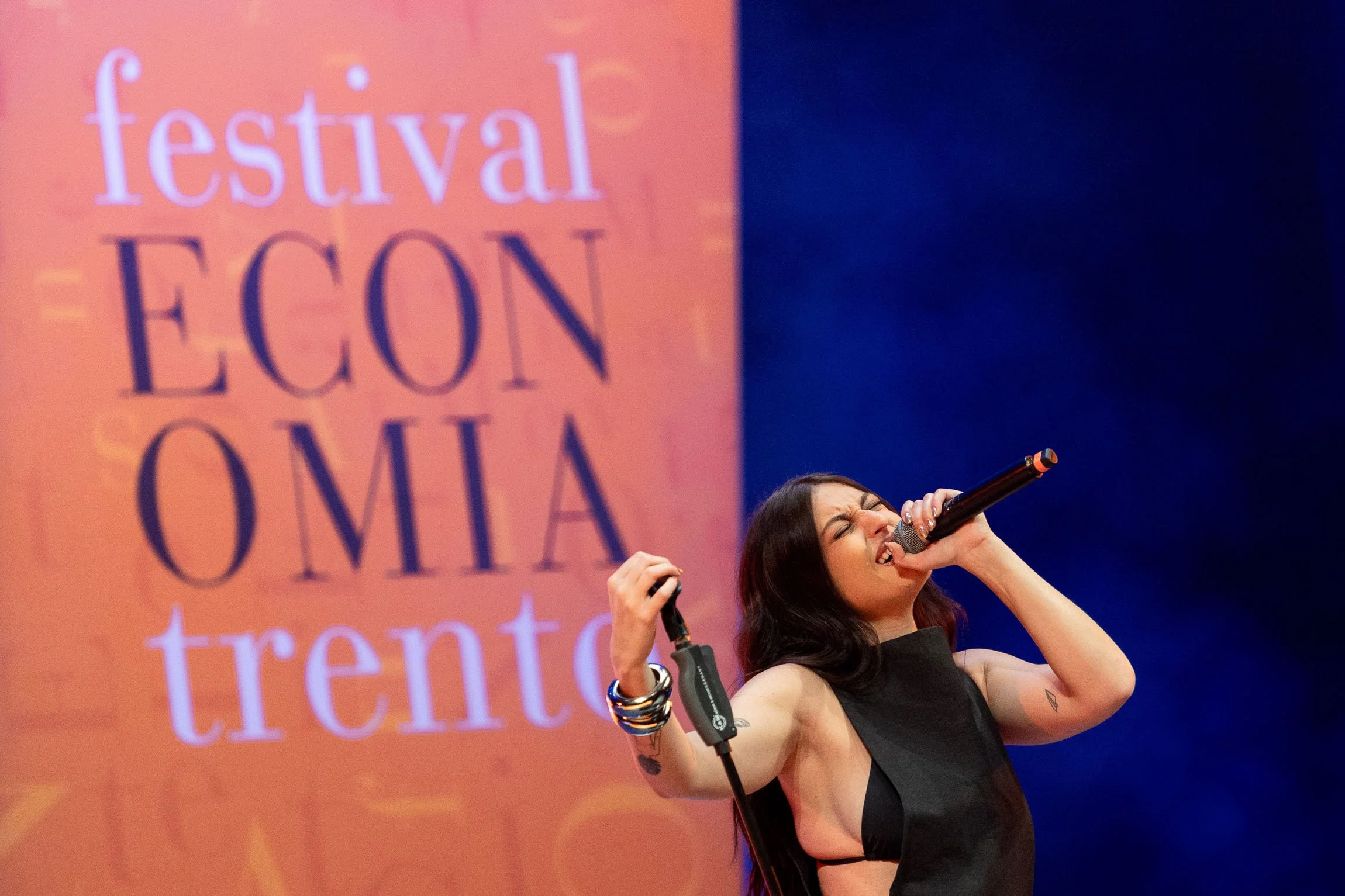 Gaia Gozzi al festival dell'economia di trento. Una donna canta con passione durante un concerto, con uno sfondo di un grande schermo con le parole ''festival con economia trento''.

© Alessandro Holneider - Archivio Ufficio Stampa PAT