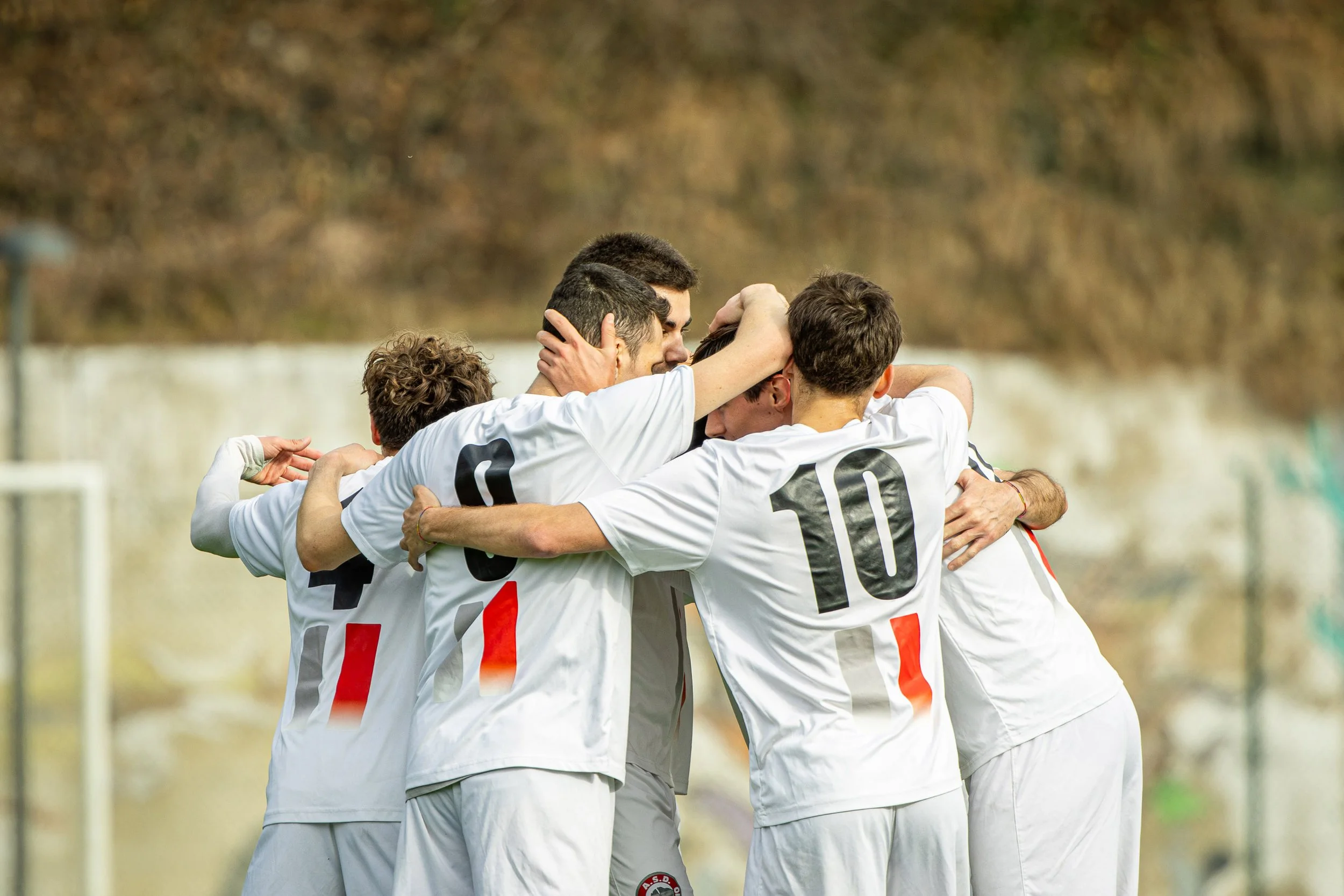 ASD CALISIO CALCIO. Gruppo di giocatori di calcio che si abbracciano durante una celebrazione sul campo

© Alessandro Holneider
