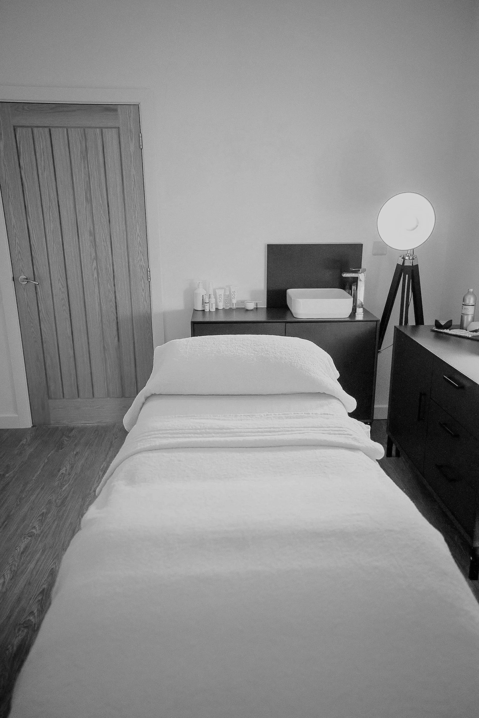 A dimly lit treatment room with a comfortable treatment bed