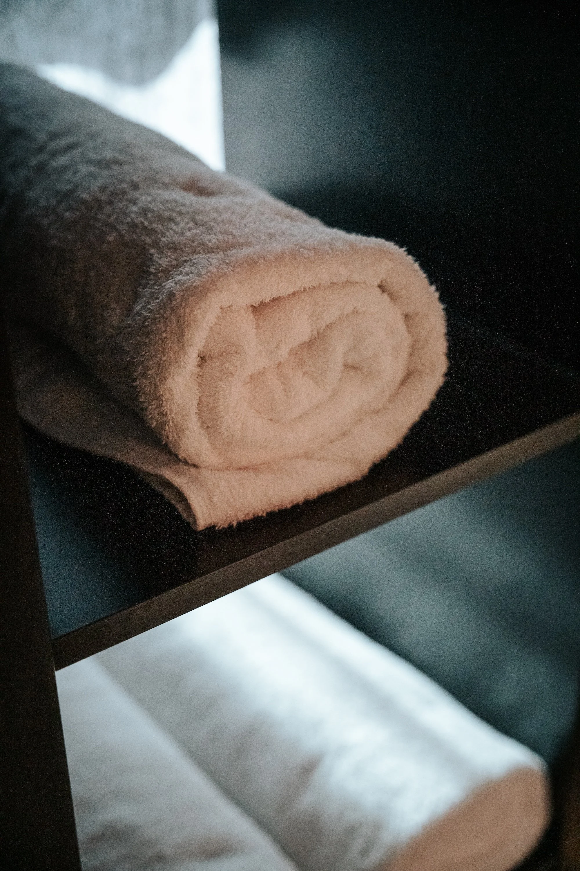 Rolled white towels on shelves