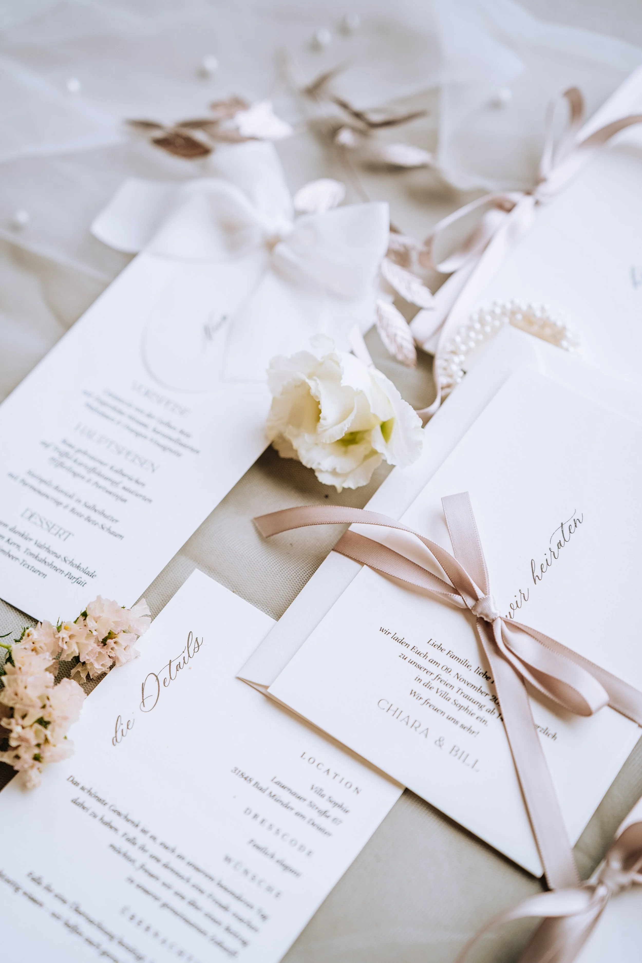 Ein Hochzeits-Einladung mit rosa Schleifen, Blumen und Dekorationen