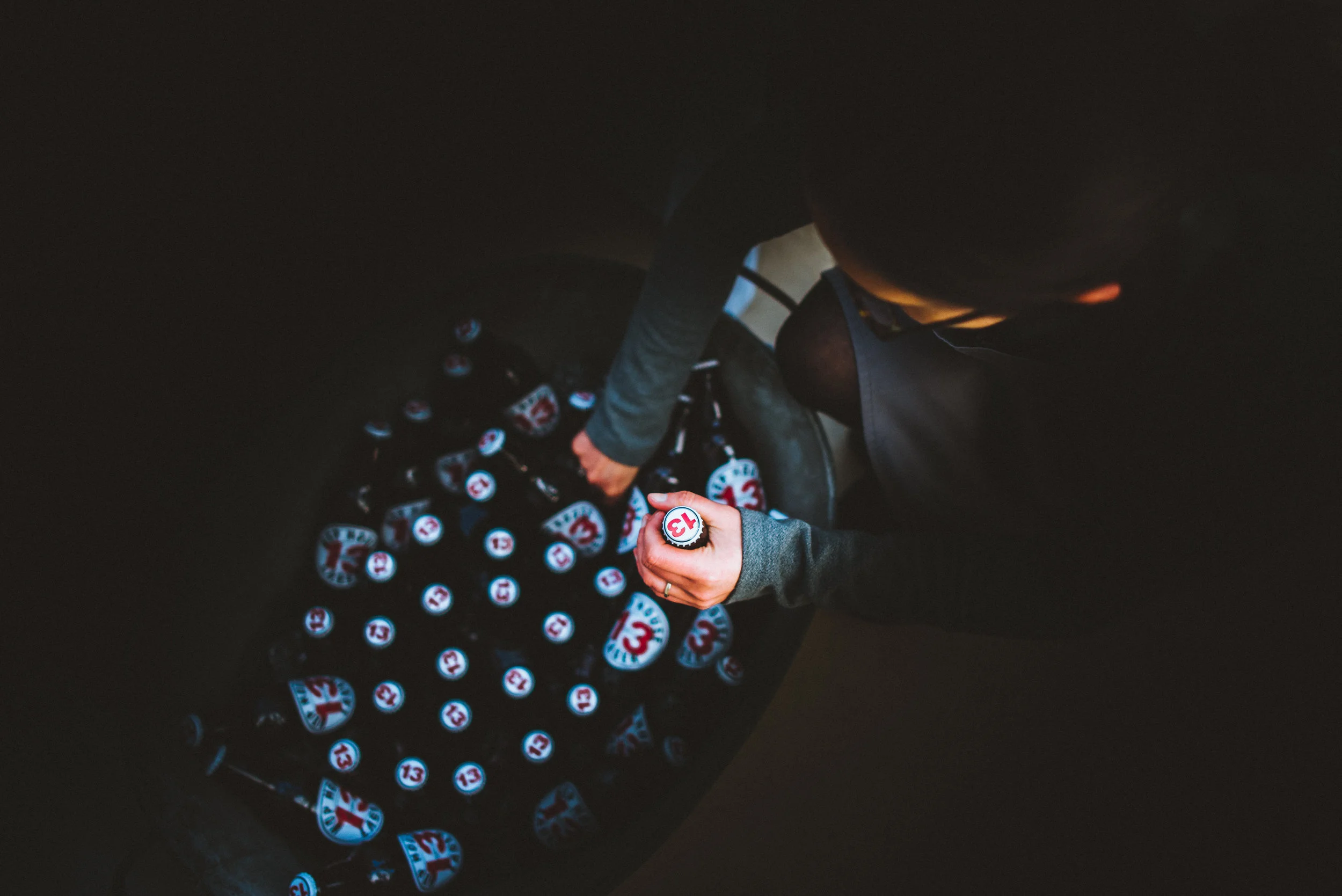 Overhead view of a person counting cans of a product labeled with the number 13 at a warehouse or store.