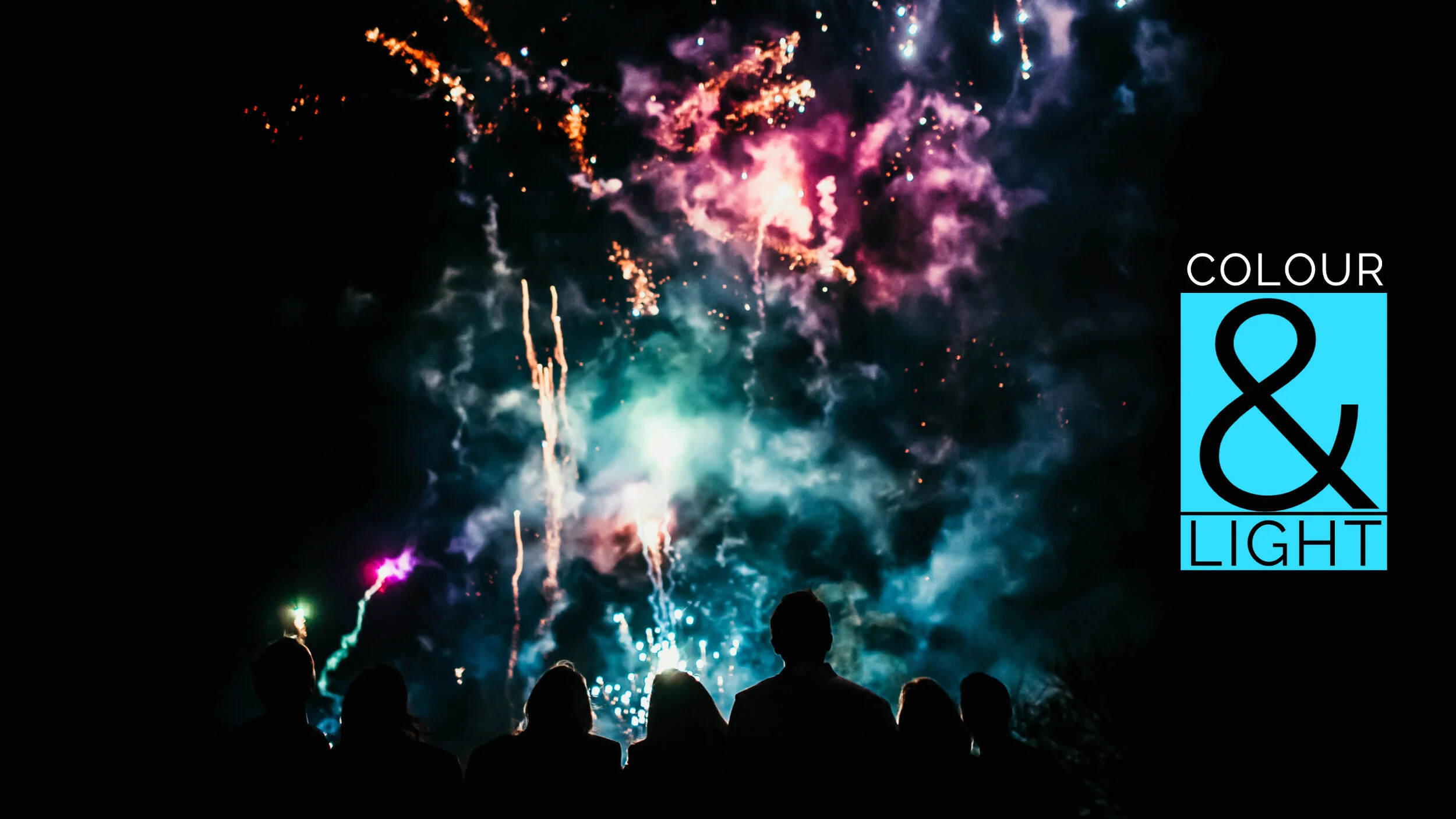 Silhouettes of people watching fireworks display at night at wedding in Cornwall