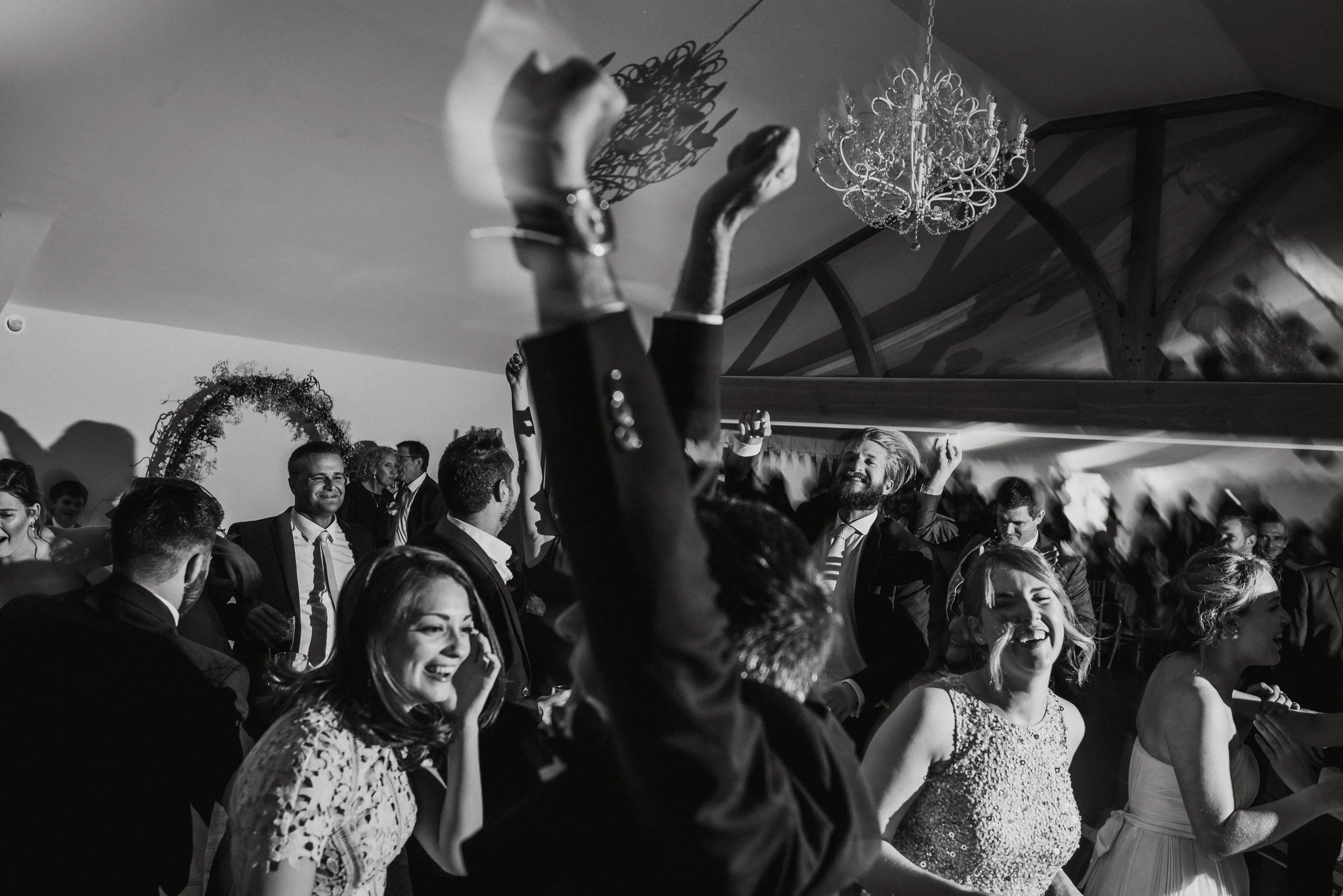 People at a party dancing and enjoying themselves in a decorated indoor venue, in black and white.