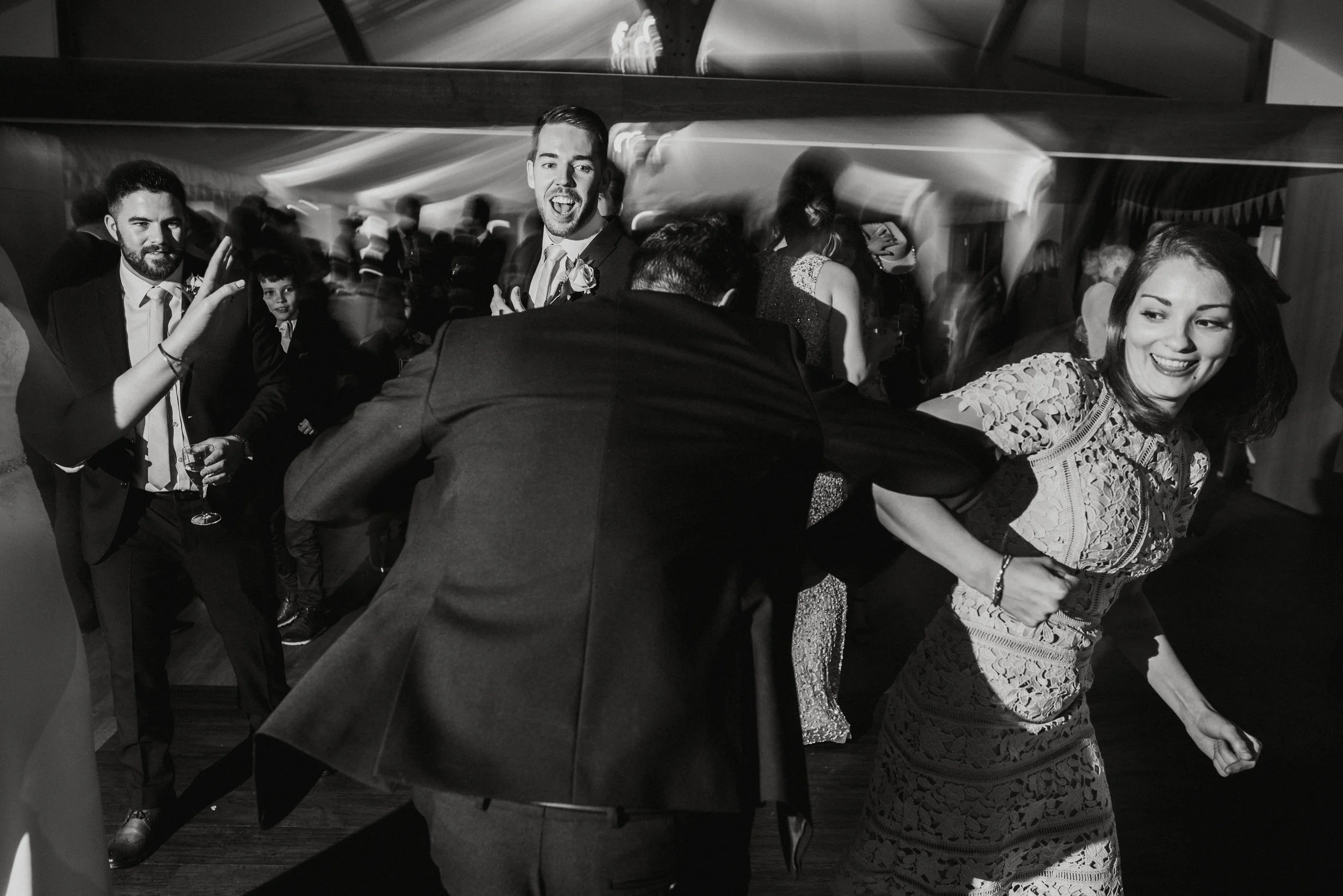 People dancing at a party, smiling and enjoying themselves, in a lively indoor setting.