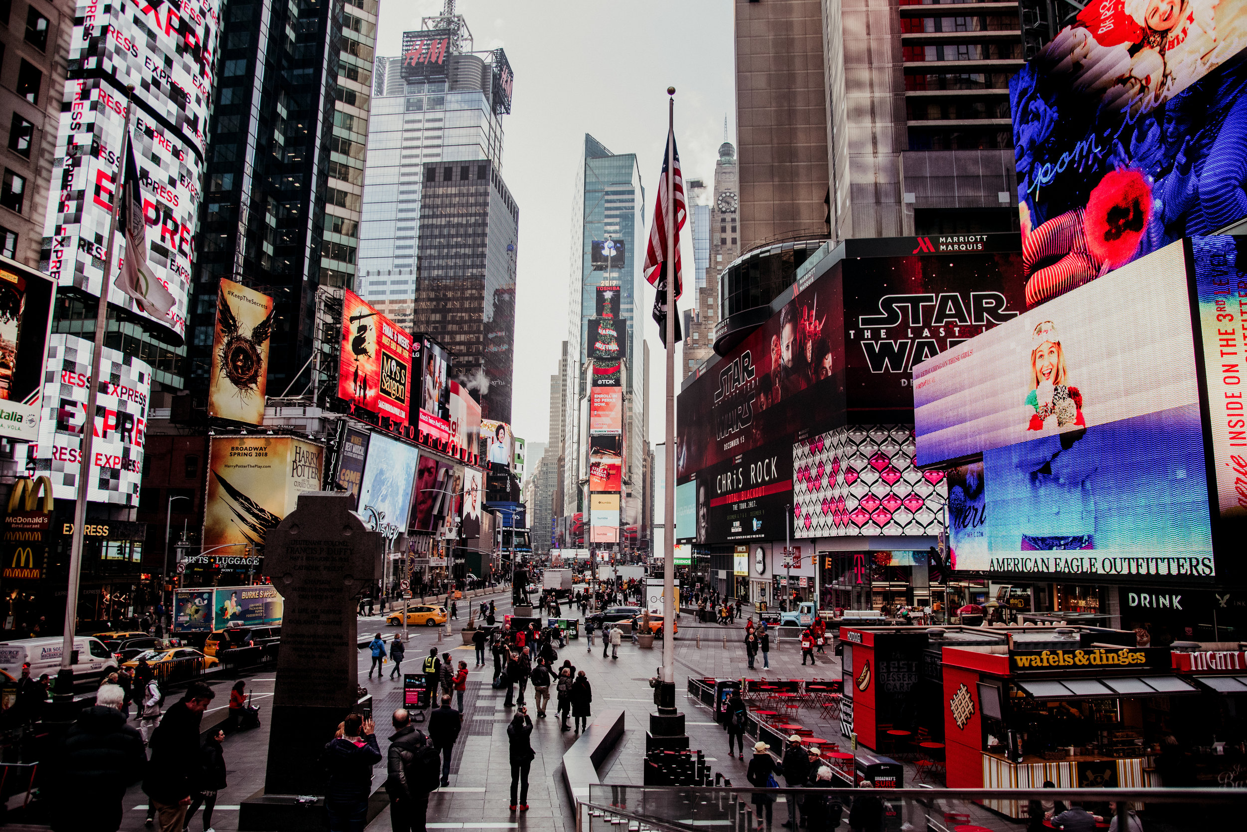 Times Square in New York City bustling with people, illuminated digital billboards, and skyscrapers.