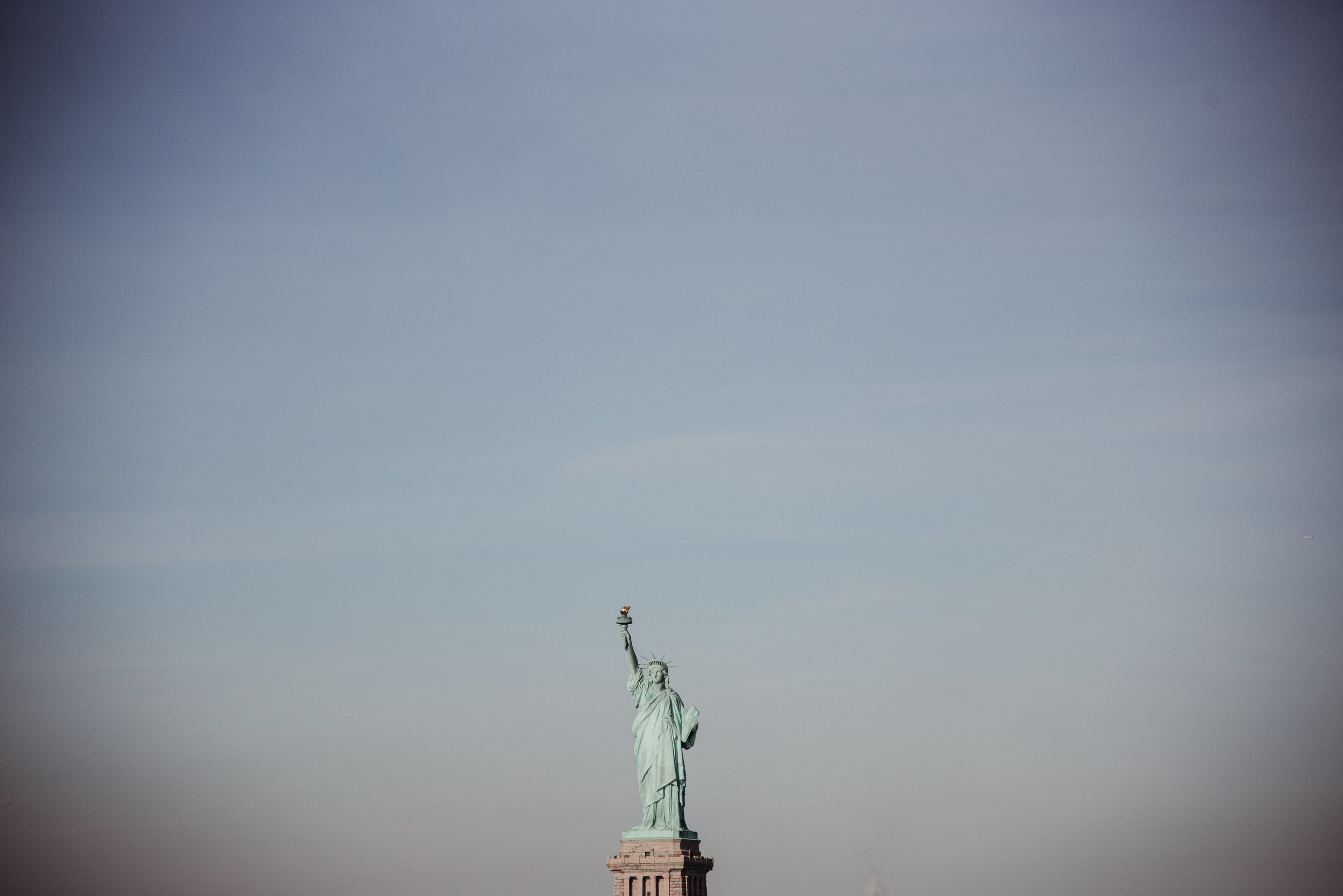 Statue of Liberty visible against a clear sky, holding a torch aloft.