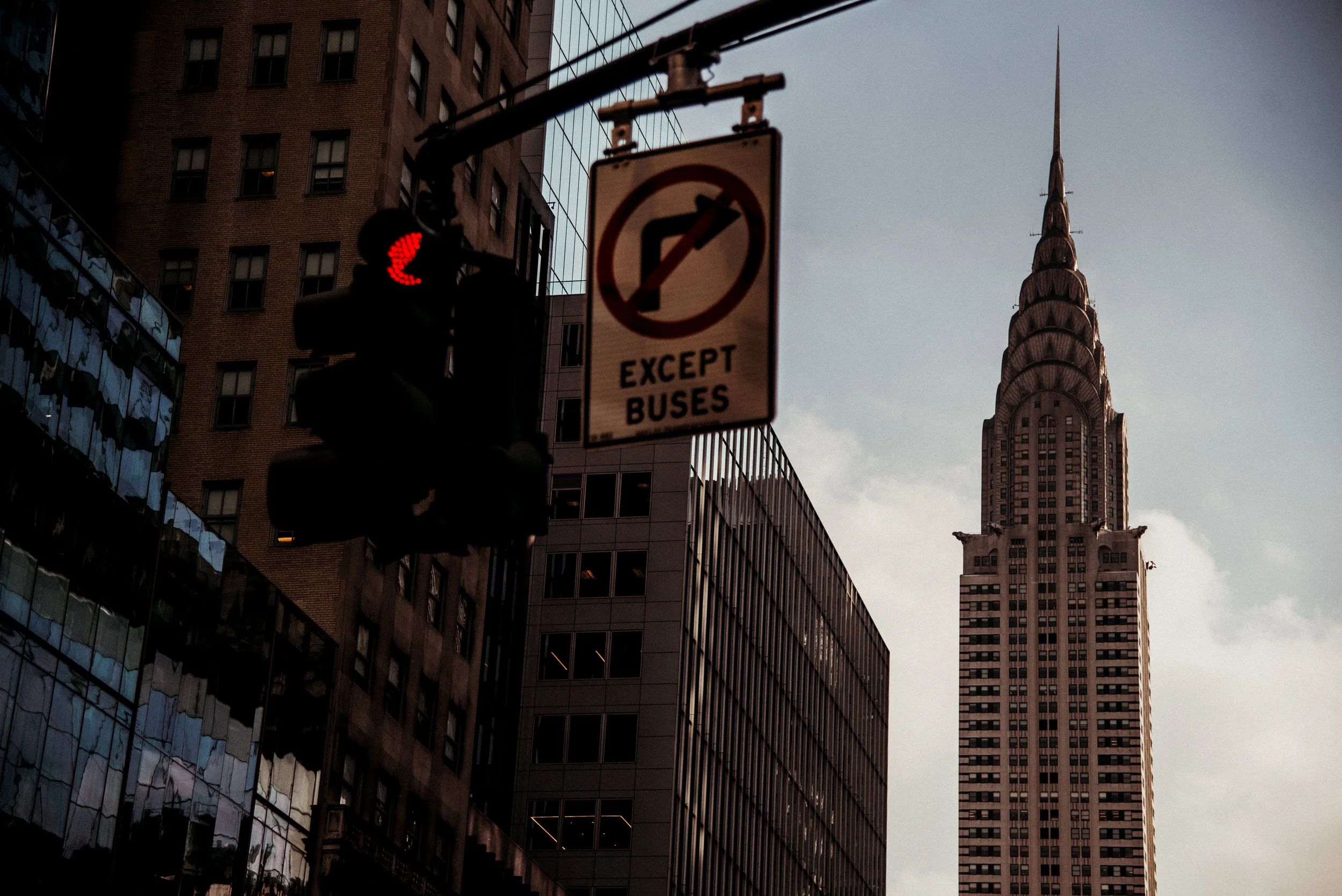 City street scene with the Chrysler Building in the background, traffic light, and a sign that reads 'Except Buses'.