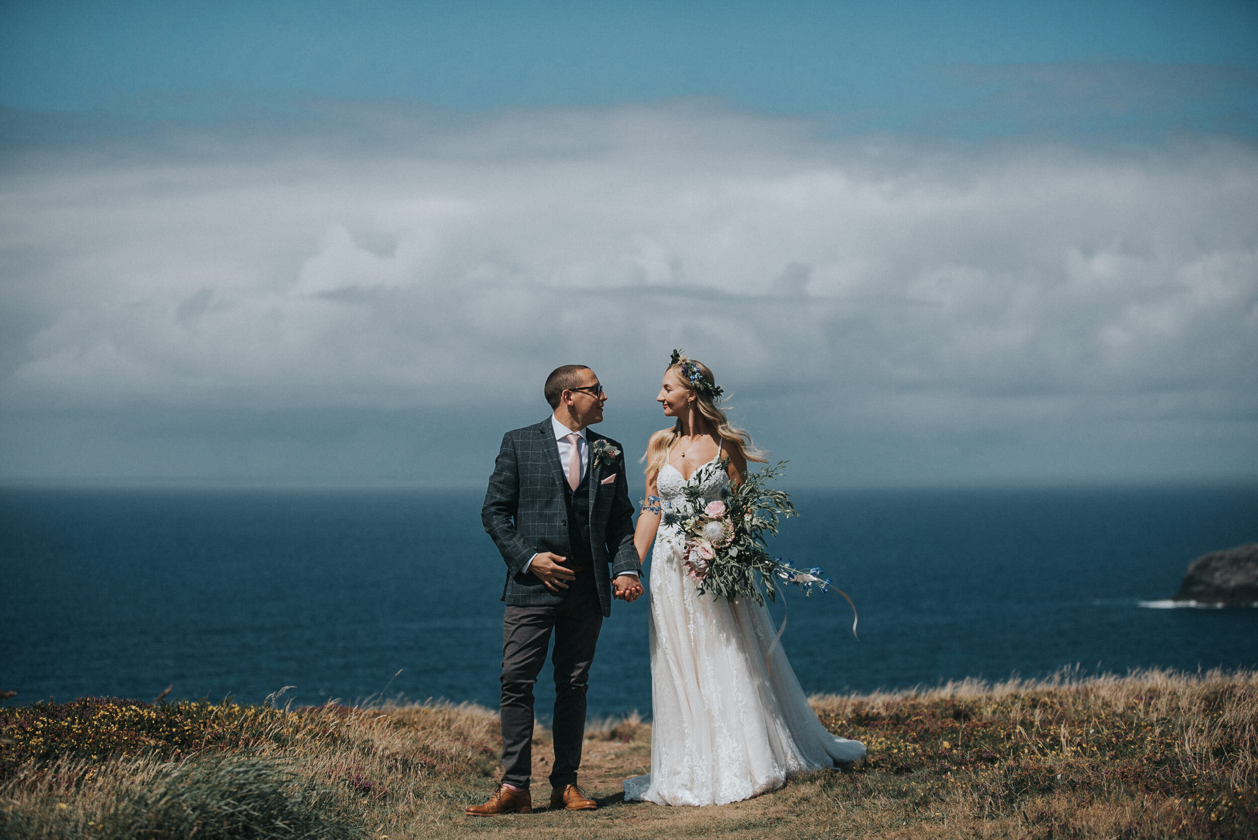 A bride and groom holding hands at St Agnes in Cornwall