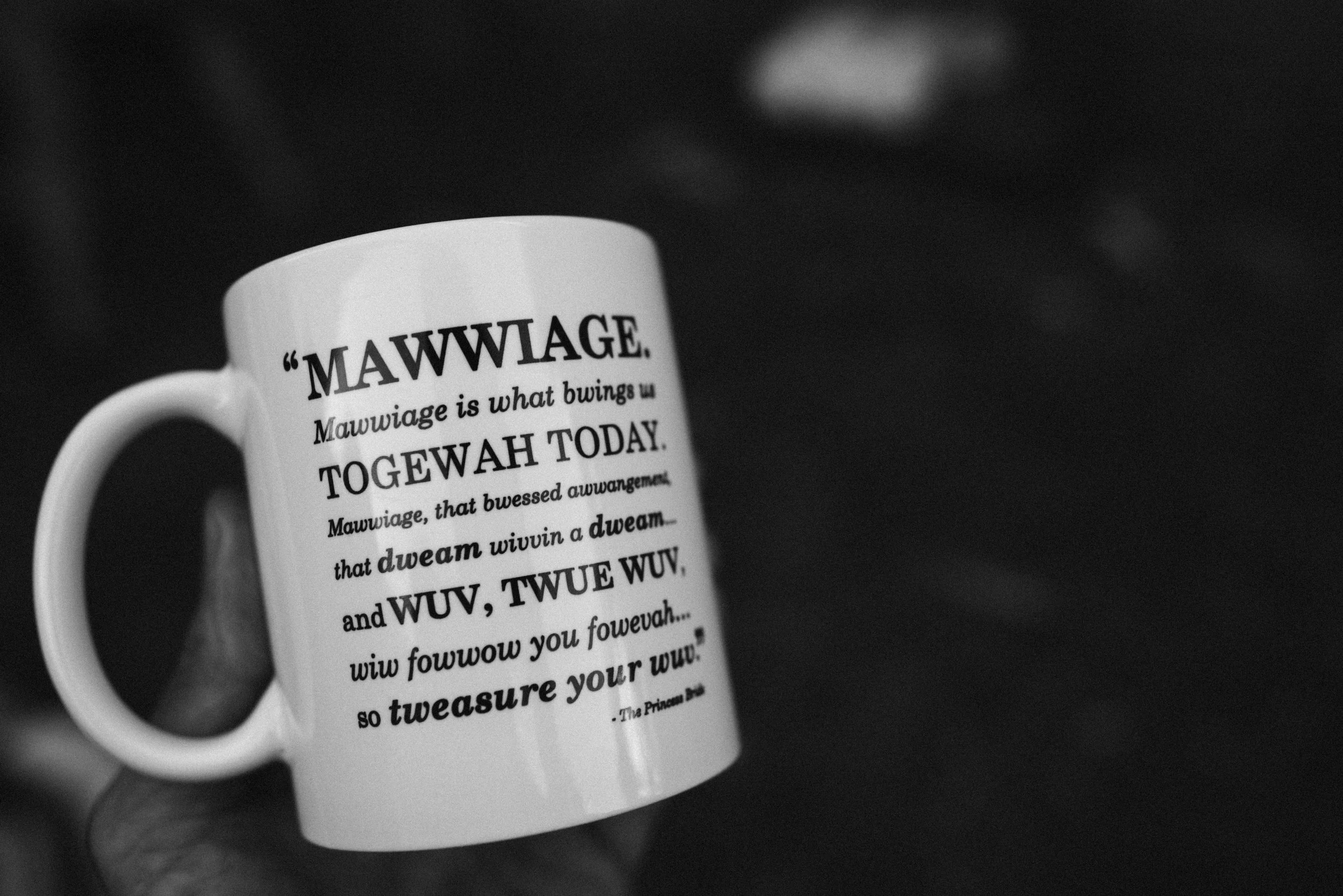 A white coffee mug with black text featuring the word 'MAWWIAGE' and humorous, misspelled wedding-related phrases printed on it.