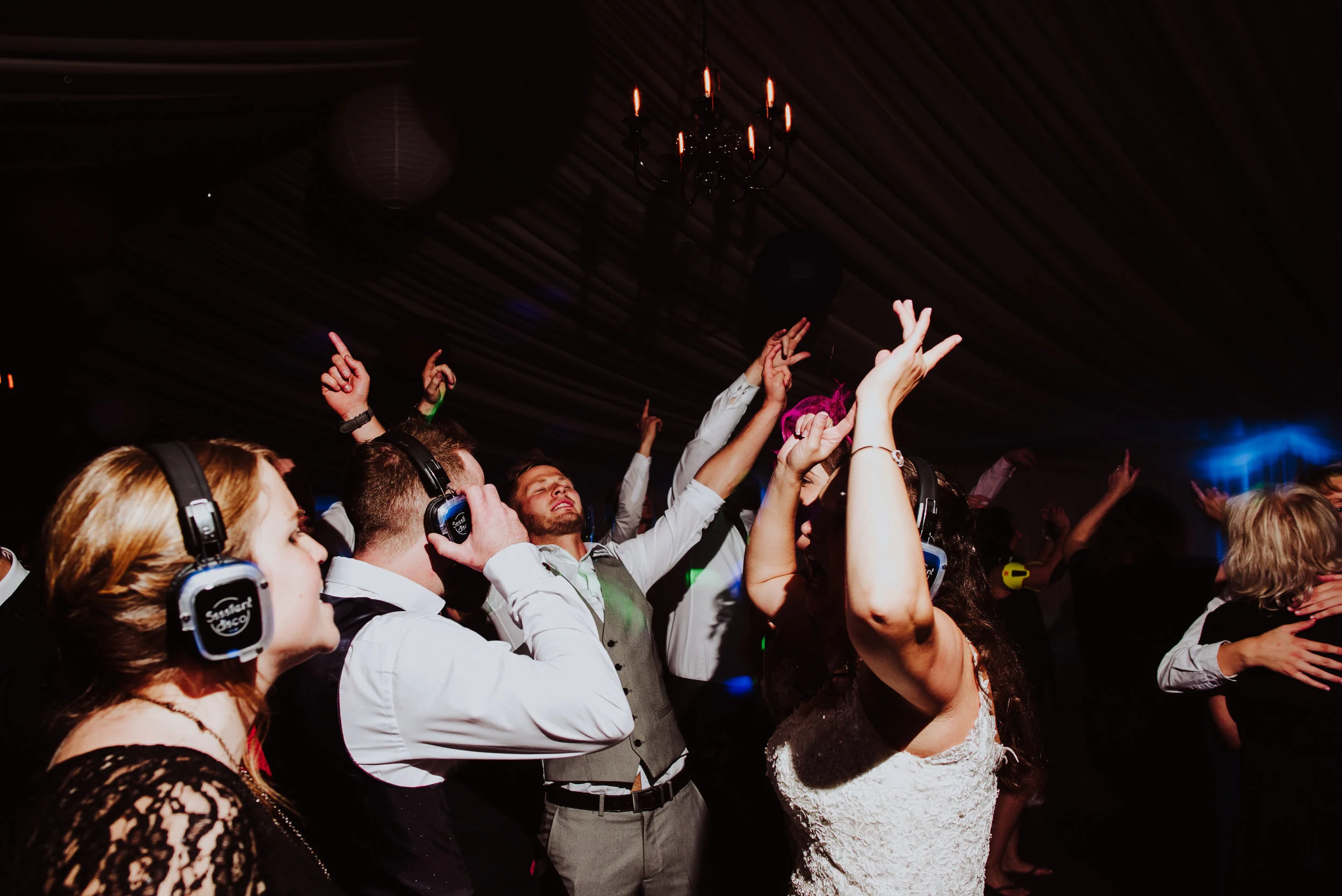 People dancing at a party or celebration with some wearing headphones.