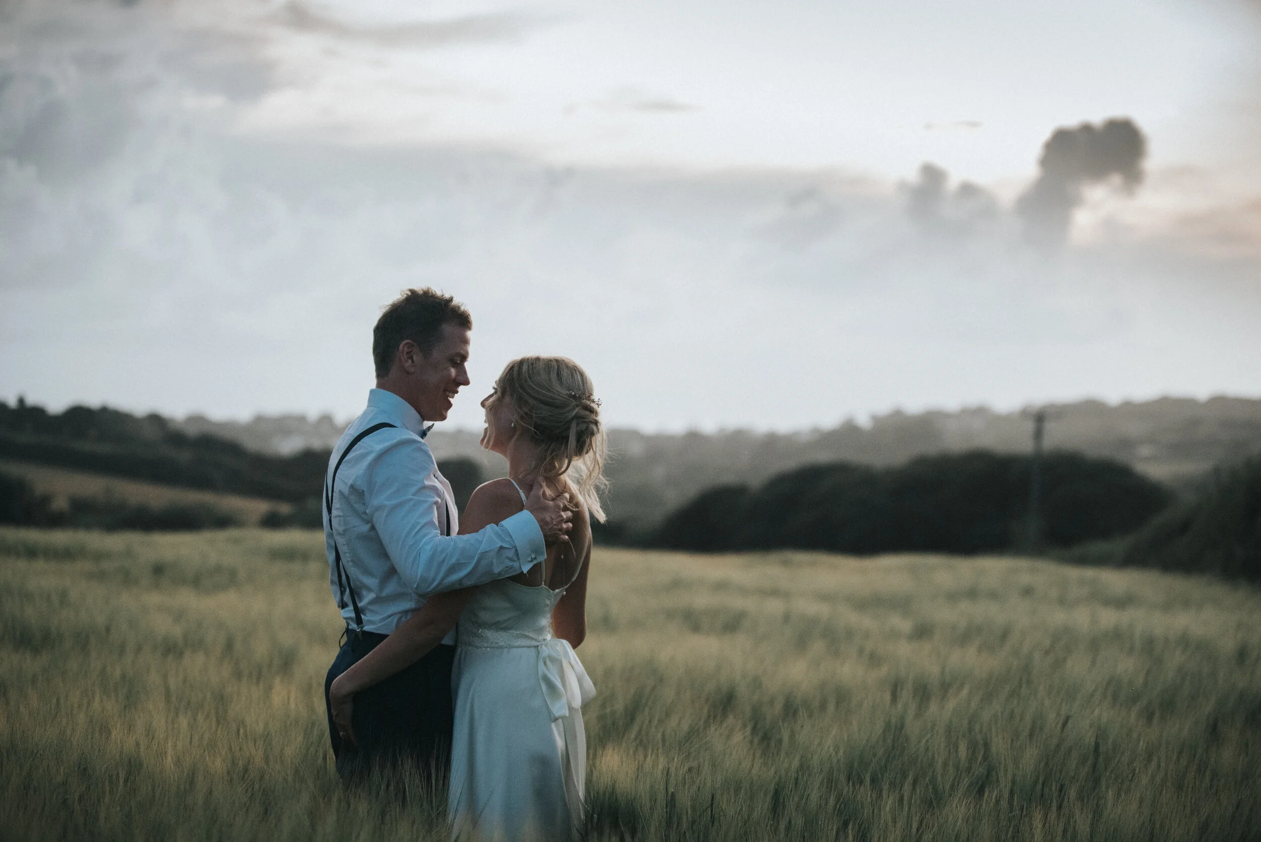 Bride and groom in fields at Launcells Barton in Bude, captured by Cornwall wedding photographer Mark Shaw Photography