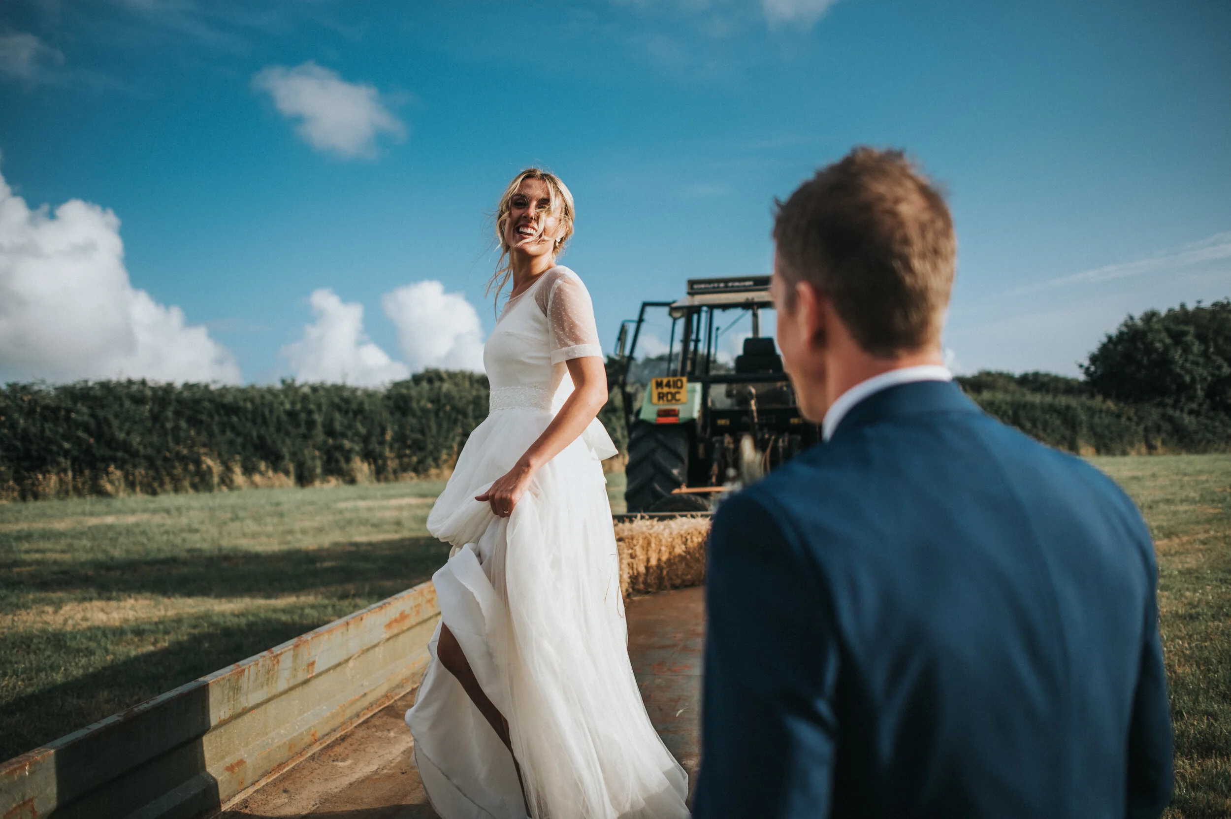A bride and groom tractor ride at Launcells Barton in Bude, captured by Cornwall wedding photographer Mark Shaw Photography
