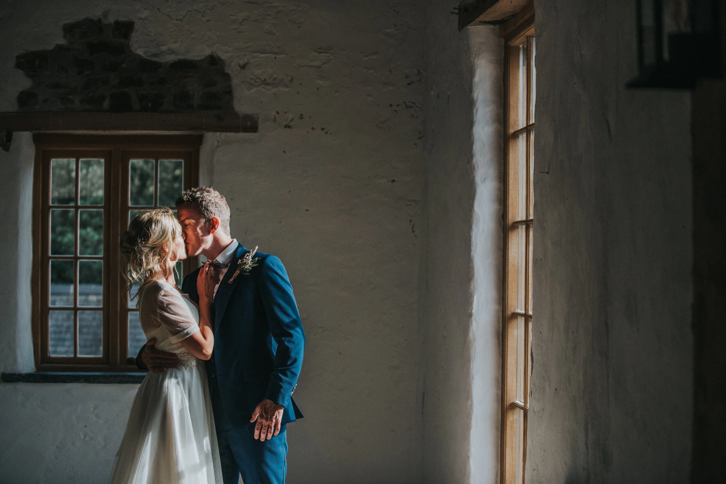 A bride and groom sharing a kiss at Launcells Barton in Bude, captured by Cornwall wedding photographer Mark Shaw Photography


