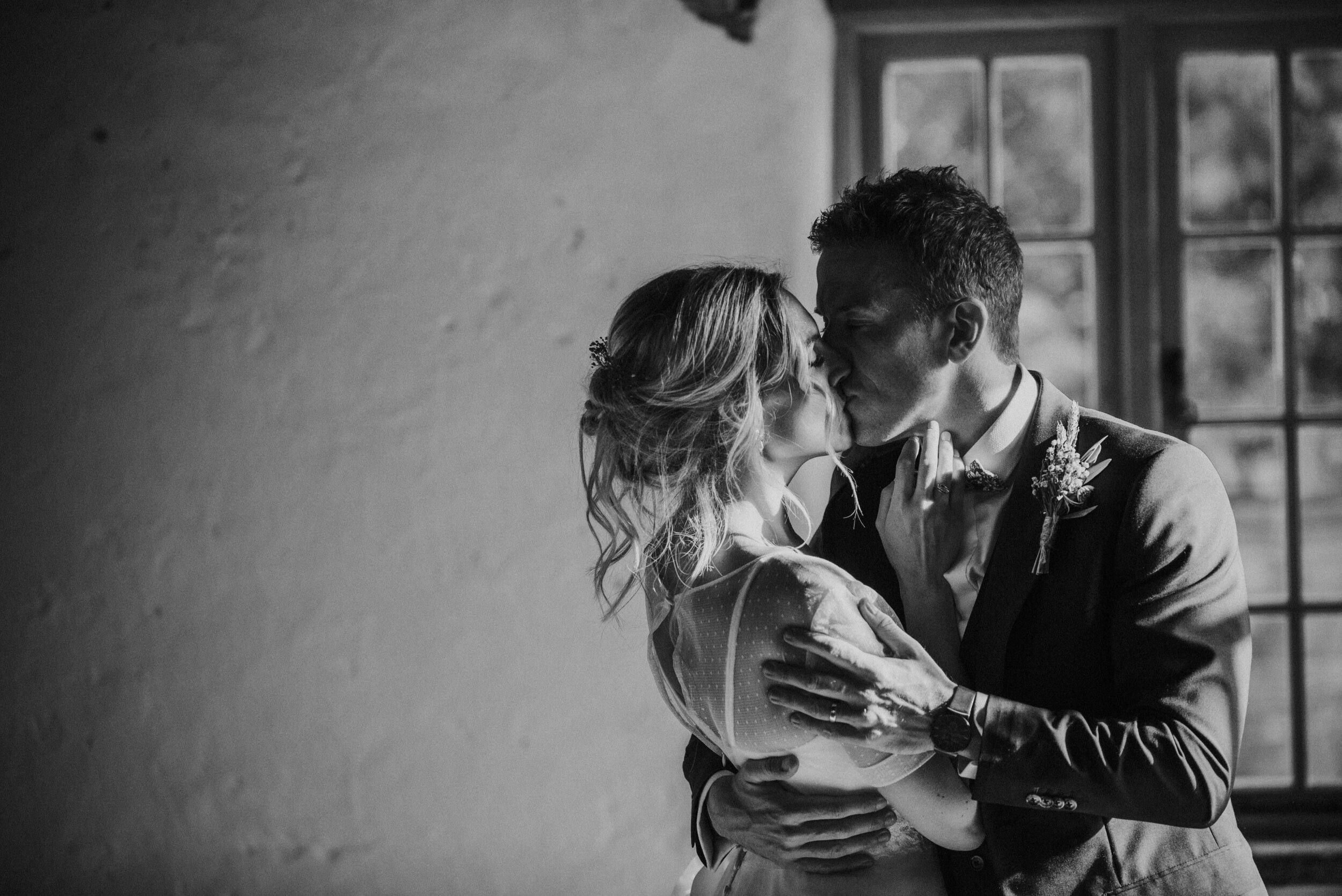A bride and groom sharing a kiss at Launcells Barton in Bude, captured by Cornwall wedding photographer Mark Shaw Photography
