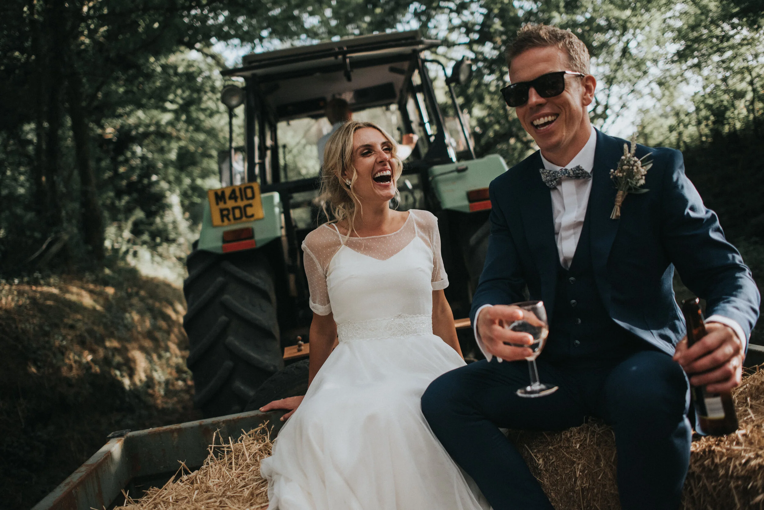 A bride and groom tractor ride at Launcells Barton in Bude, captured by Cornwall wedding photographer Mark Shaw Photography